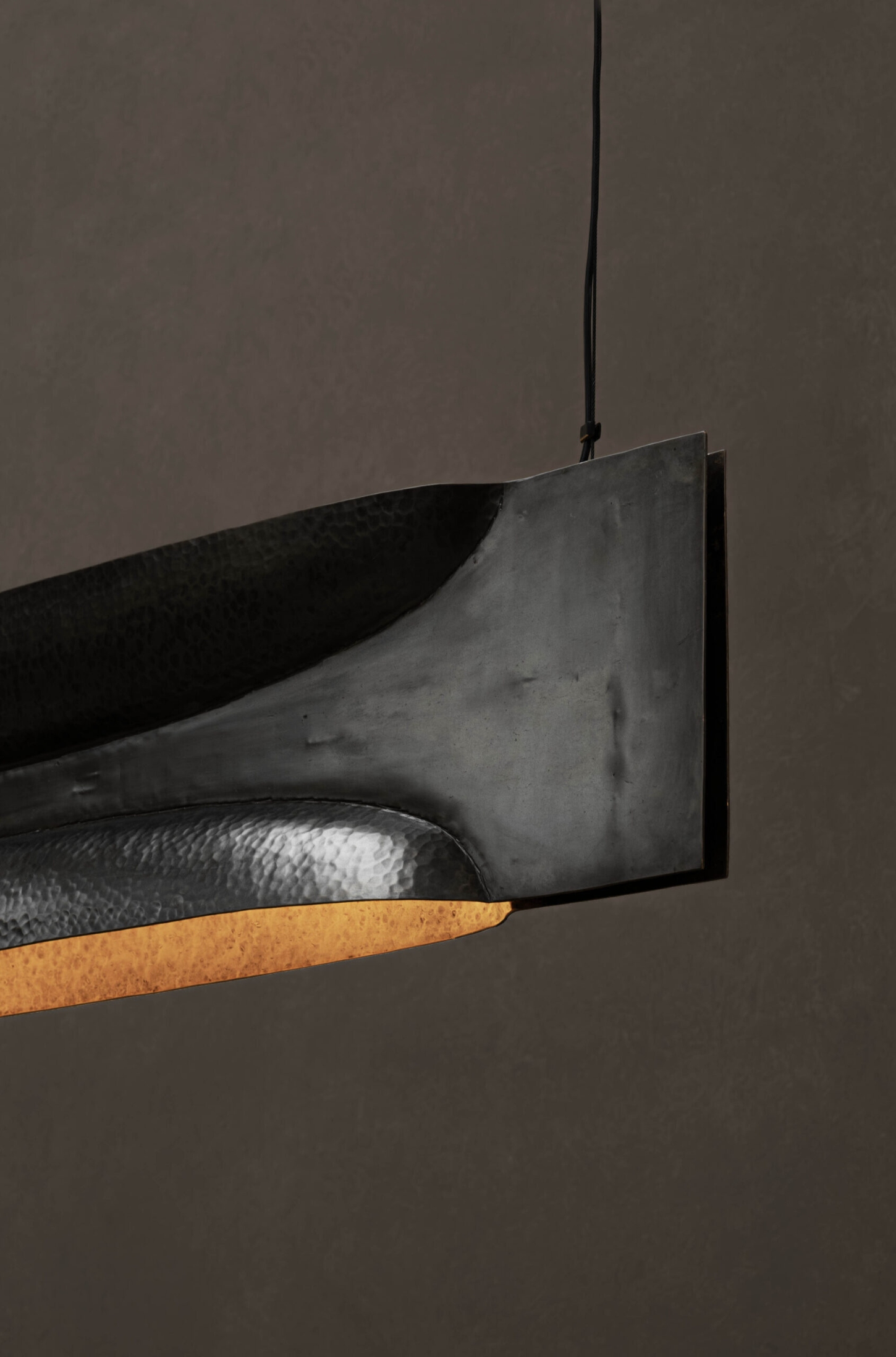 New Works by Manu Bañó — A suspended copper lamp photographed in close-up detail against a neutral ground.