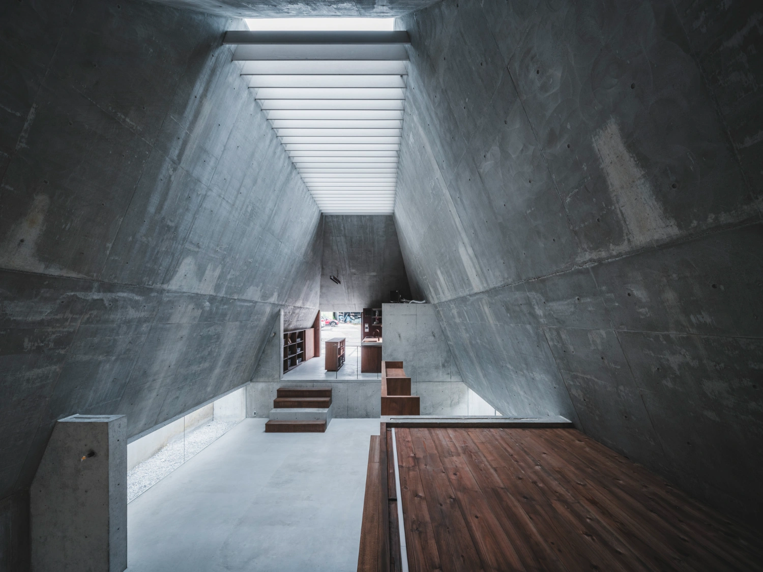 Pyramid Hut by IGArchitects — A linear perspective down the interior void reveals the pyramid's inverted geometry.