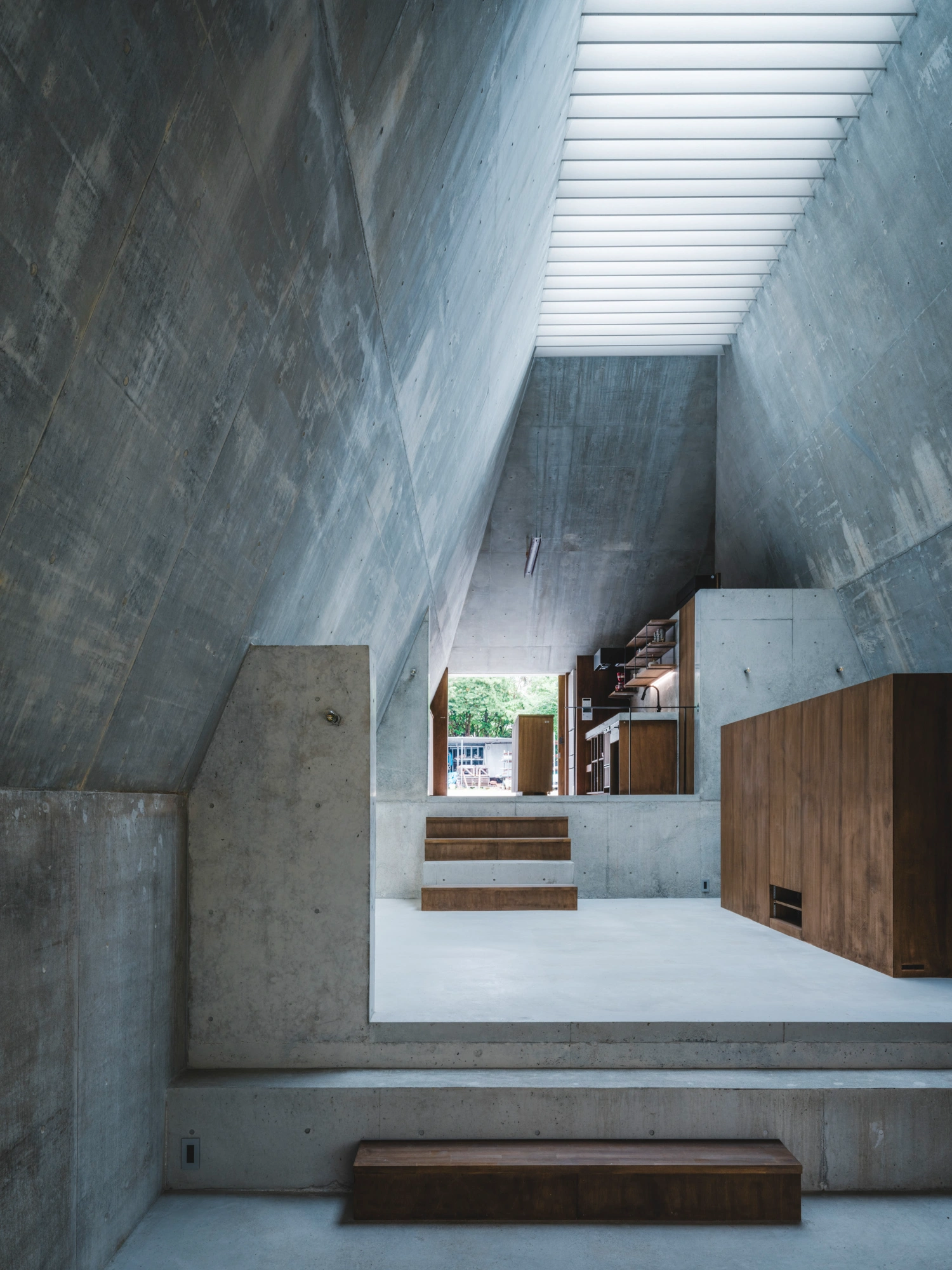 Pyramid Hut by IGArchitects — A sunlit concrete interior viewed from a lower level, revealing the volumetric depth of Pyramid Hut's monolithic-cast structure.