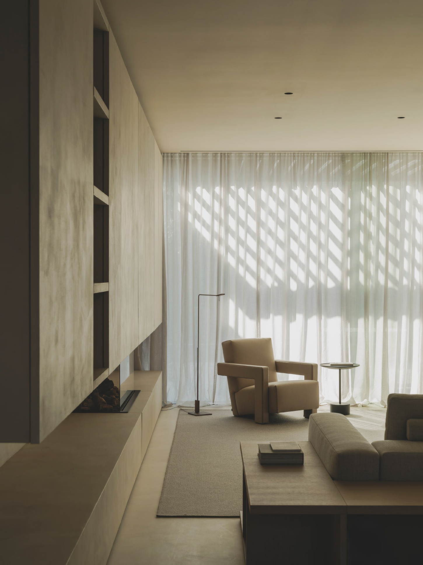 S29 House by Francesc Rifé Studio + Exit Projectes — A living area with cream linen floor-to-ceiling curtains filtering geometric patterns of natural light across the space.