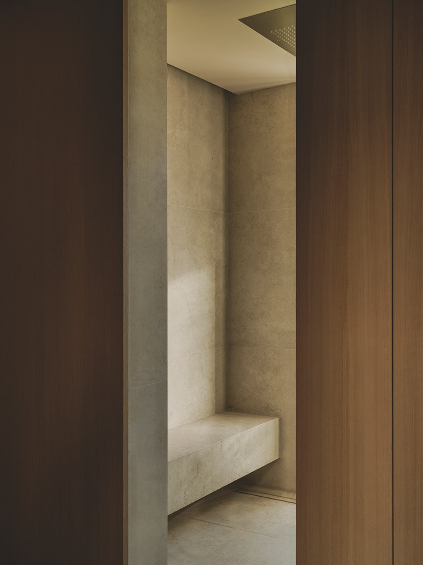 S29 House by Francesc Rifé Studio + Exit Projectes — A narrow passage reveals a recessed alcove with cream-rendered walls and a white bench seat integrated into the base.