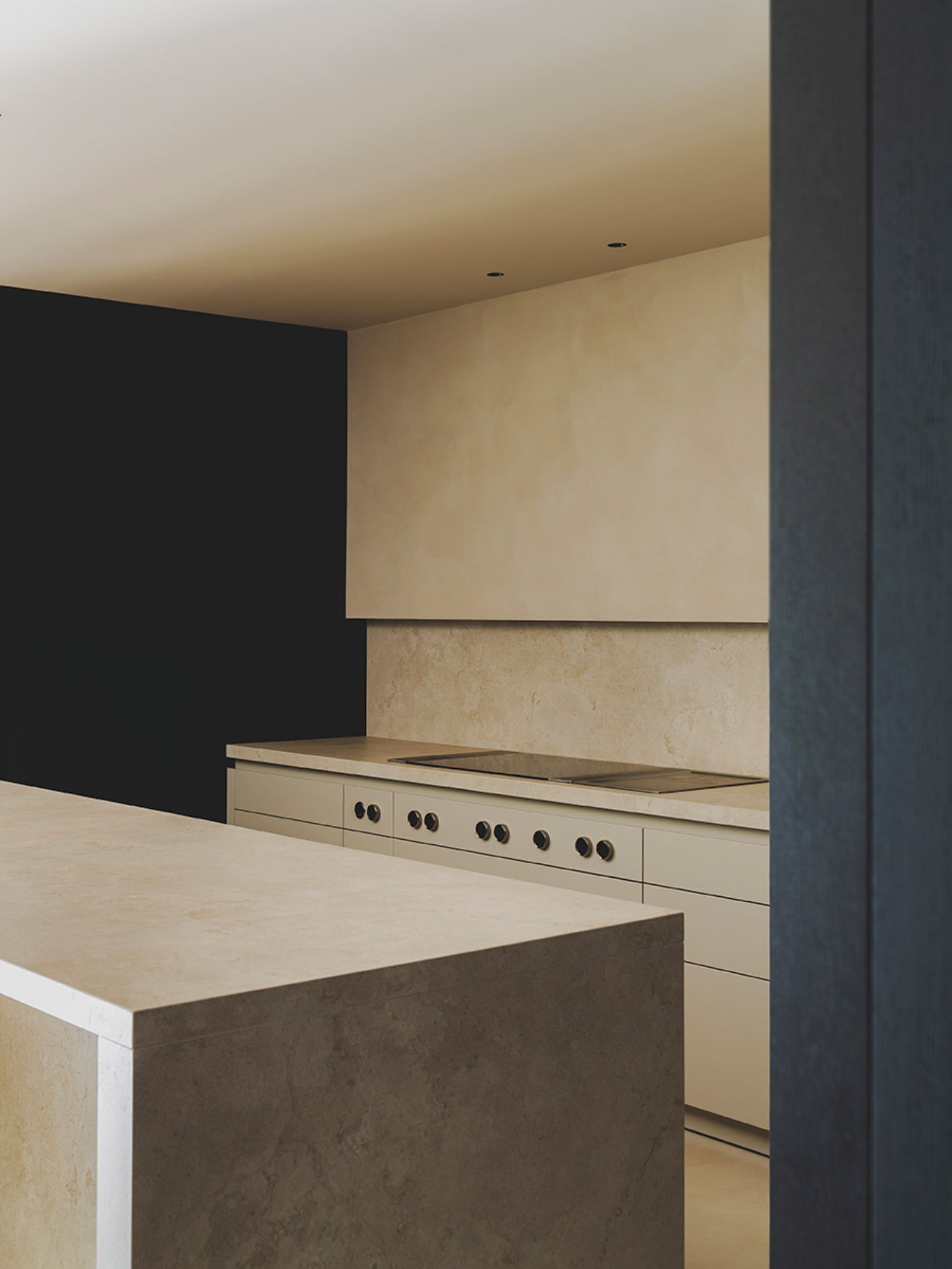 S29 House by Francesc Rifé Studio + Exit Projectes — Kitchen interior featuring a linear composition of built-in appliances set within a cream plaster wall.
