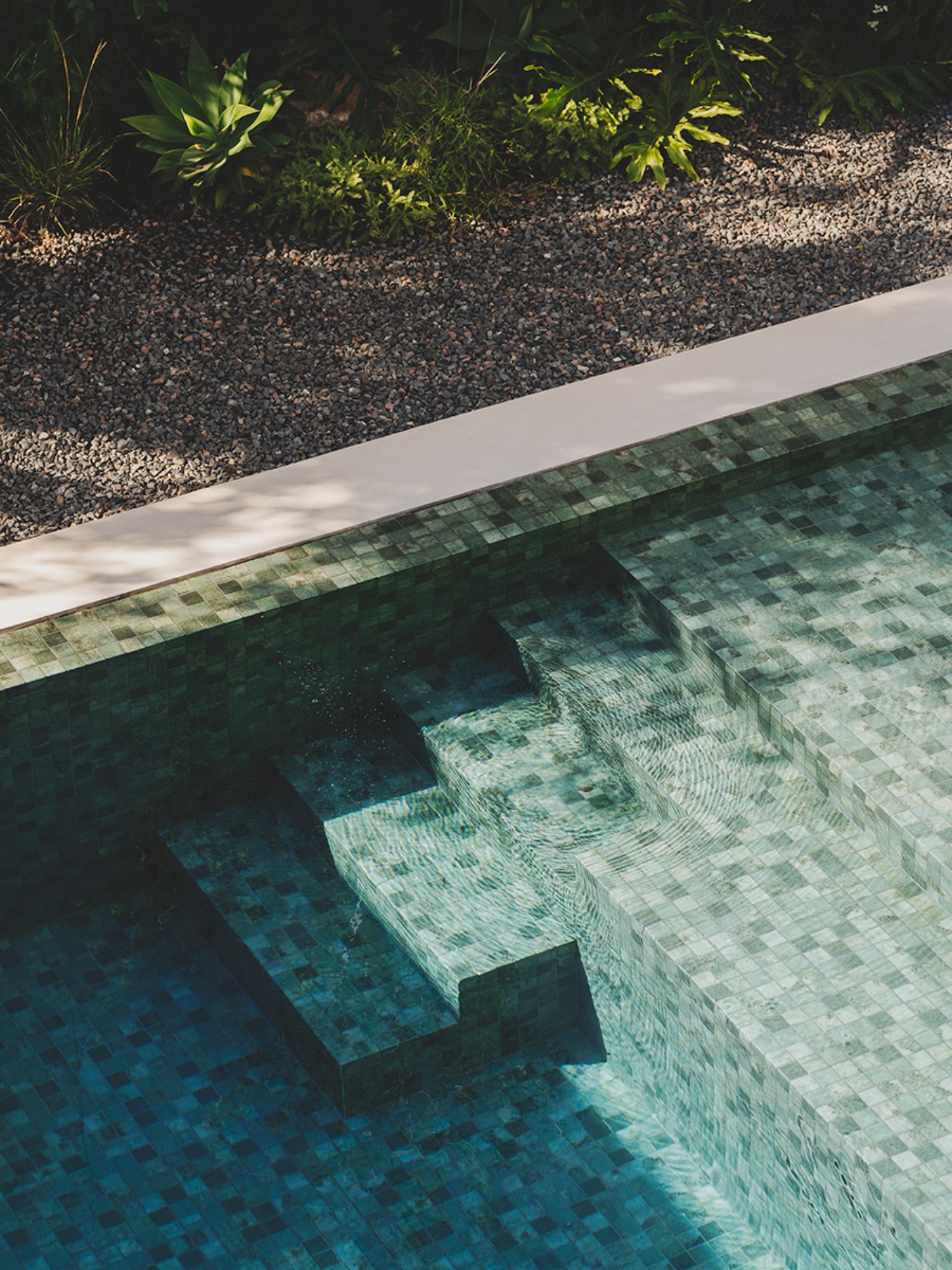 S29 House by Francesc Rifé Studio + Exit Projectes — Overhead view of the S29 House swimming pool reveals terrazzo flooring in graduated green and cream tones, creating visual depth through the water.