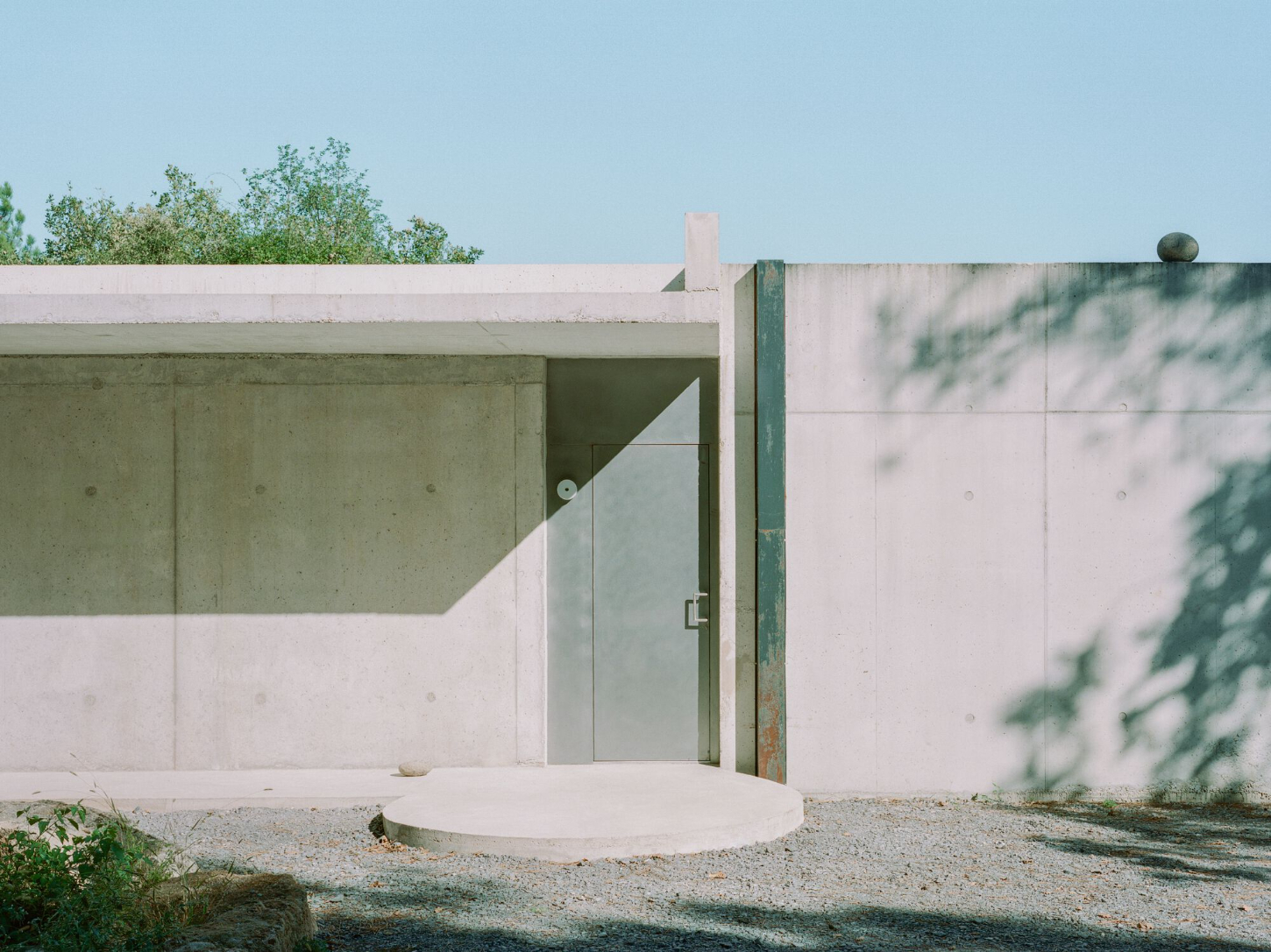 PAYZ House by Alors Studio — The PAYZ House entrance is rendered as a geometric threshold, its monolithic concrete facade divided into horizontal bands of sage and cream.