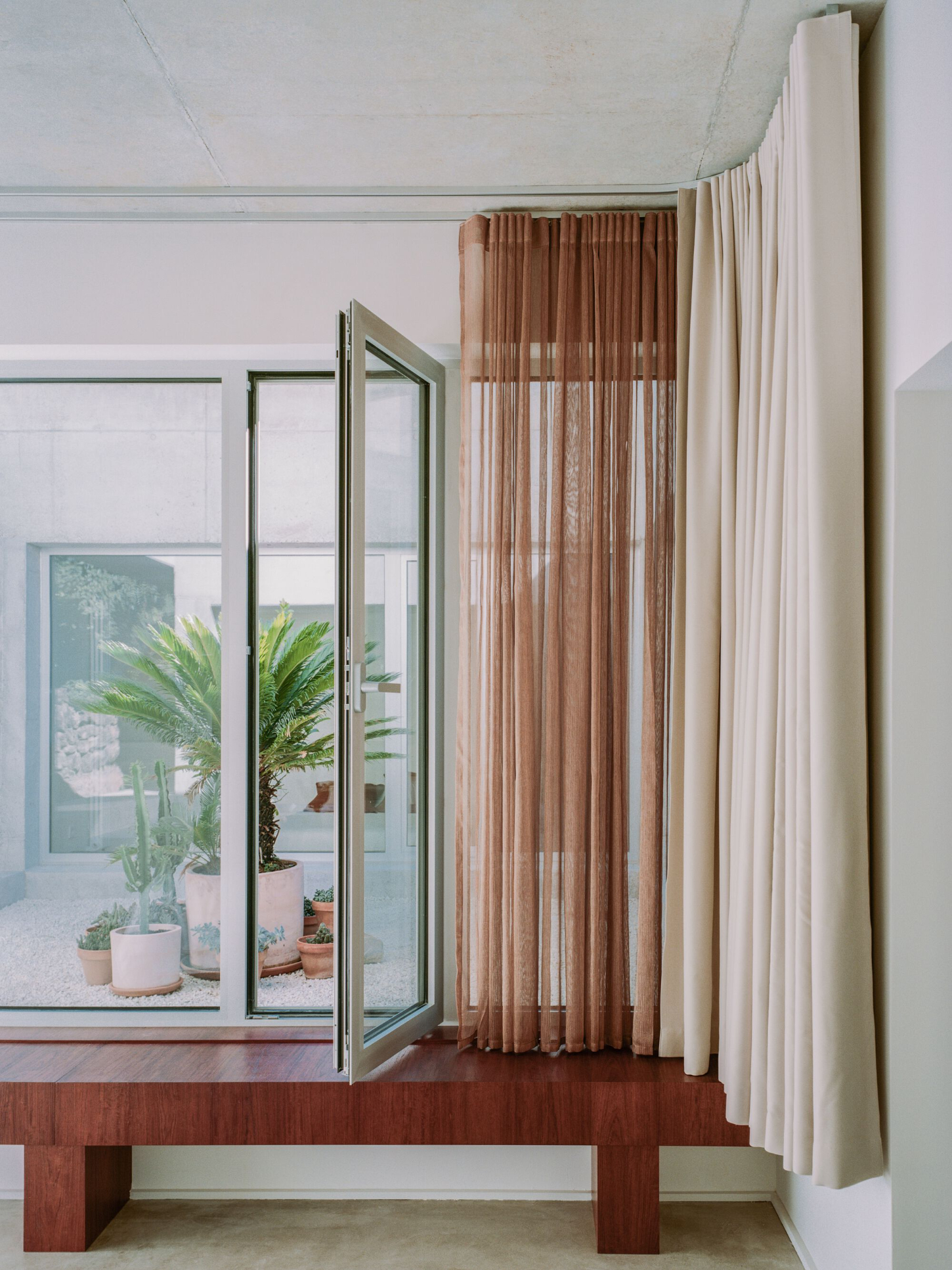PAYZ House by Alors Studio — A bedroom interior framed by white-painted timber window casings that function as architectural portals.