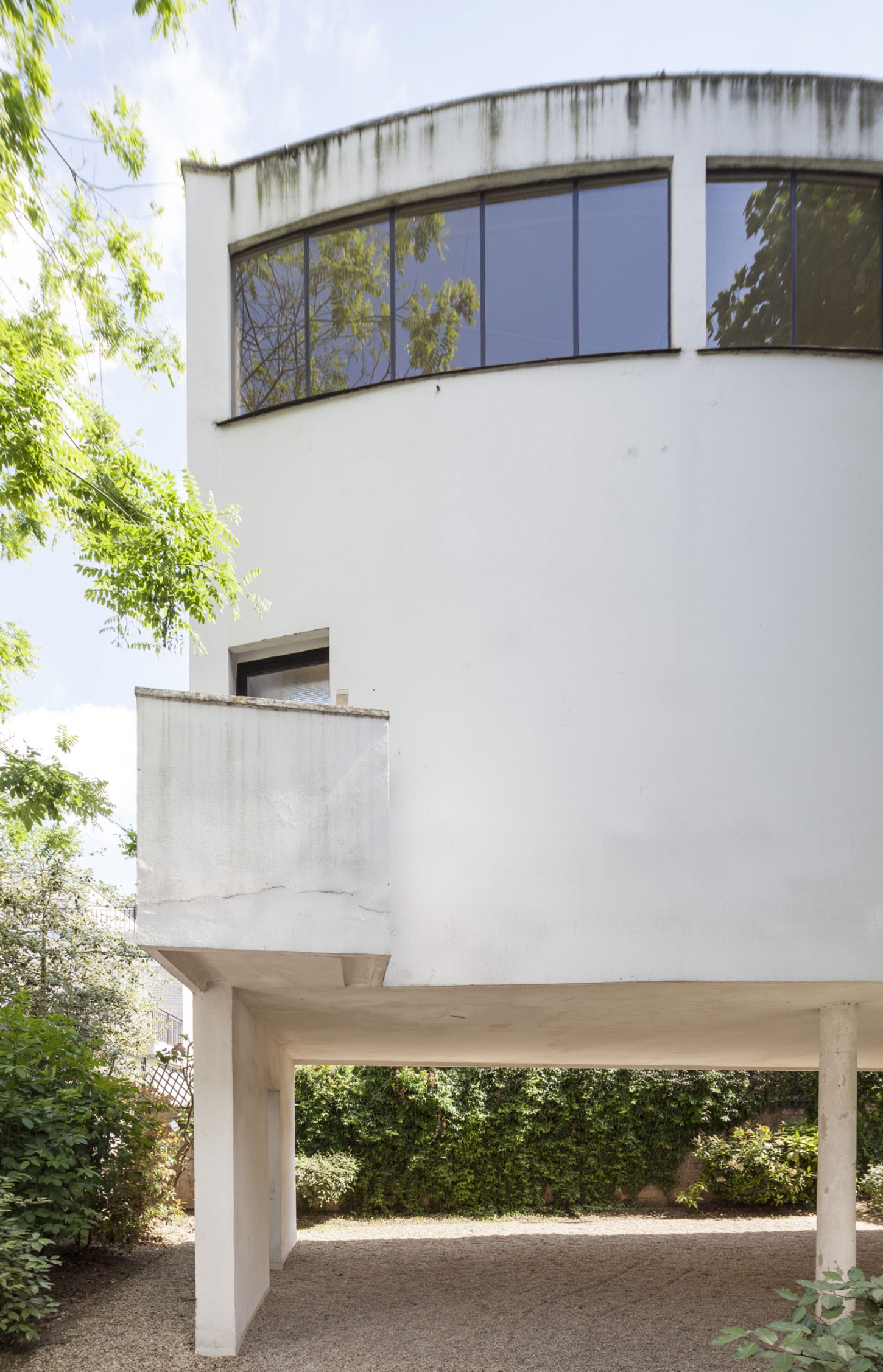 Maison La Roche-Jeanneret by Le Corbusier by Le Corbusier and Pierre Jeanneret — The garden facade of Maison La Roche-Jeanneret reveals Le Corbusier's volumetric language: a white-rendered concrete cylinder anchored by a recessed...