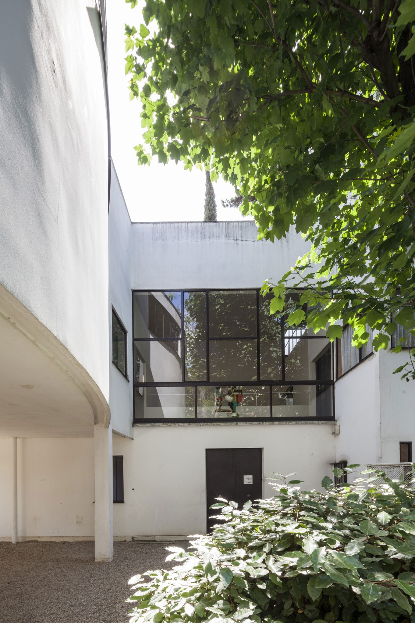 Maison La Roche-Jeanneret by Le Corbusier by Le Corbusier and Pierre Jeanneret — Courtyard view of the interconnected duplex reveals the rational geometric composition characteristic of Le Corbusier's modernist vocabulary.