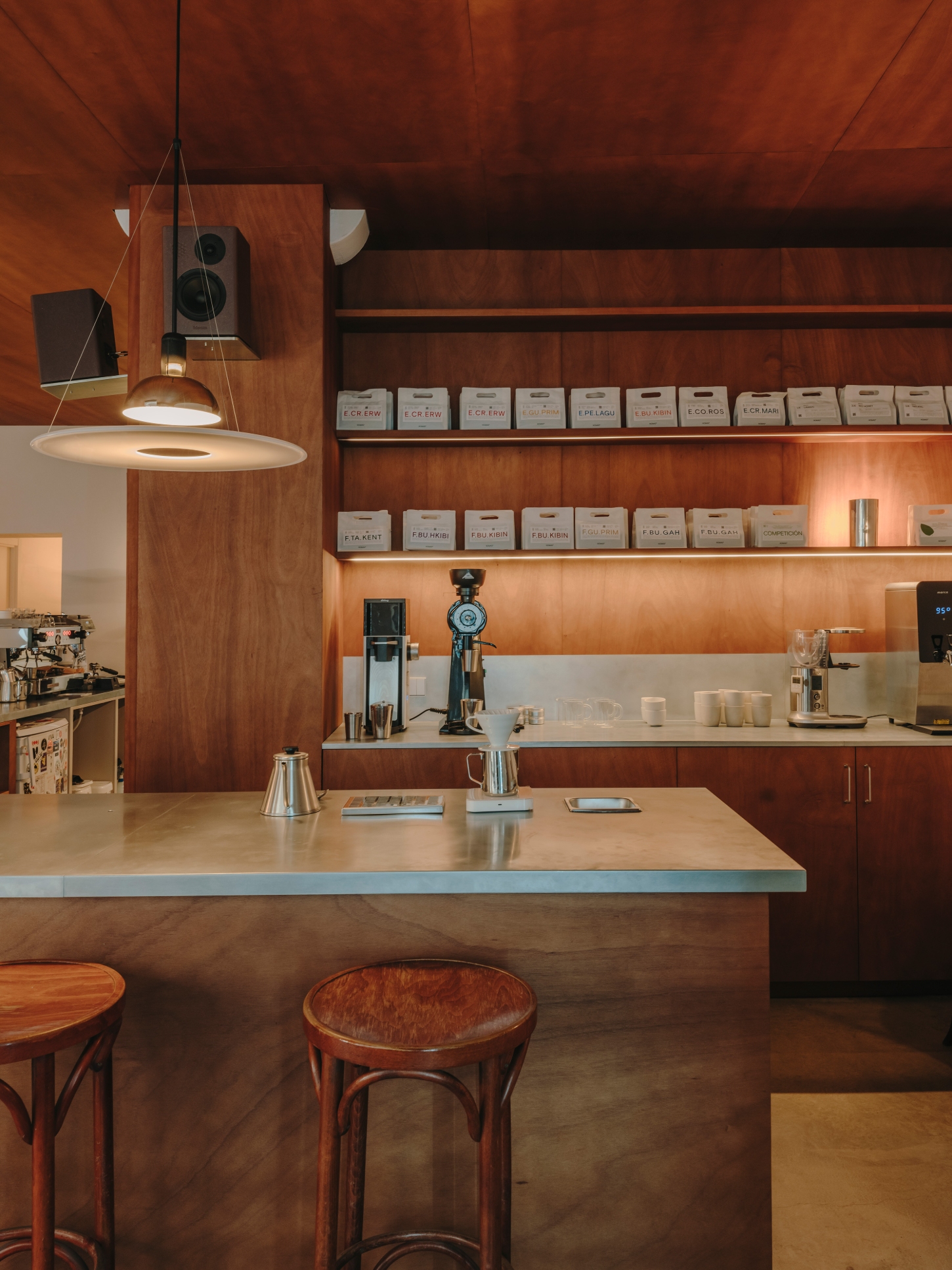 Nomad Coffee Frutas Selectas by Skye Maunsell and Jordi Veciana — The café counter becomes a sculptural focal point, anchored by a curved timber edge and zinc sheet work surface.