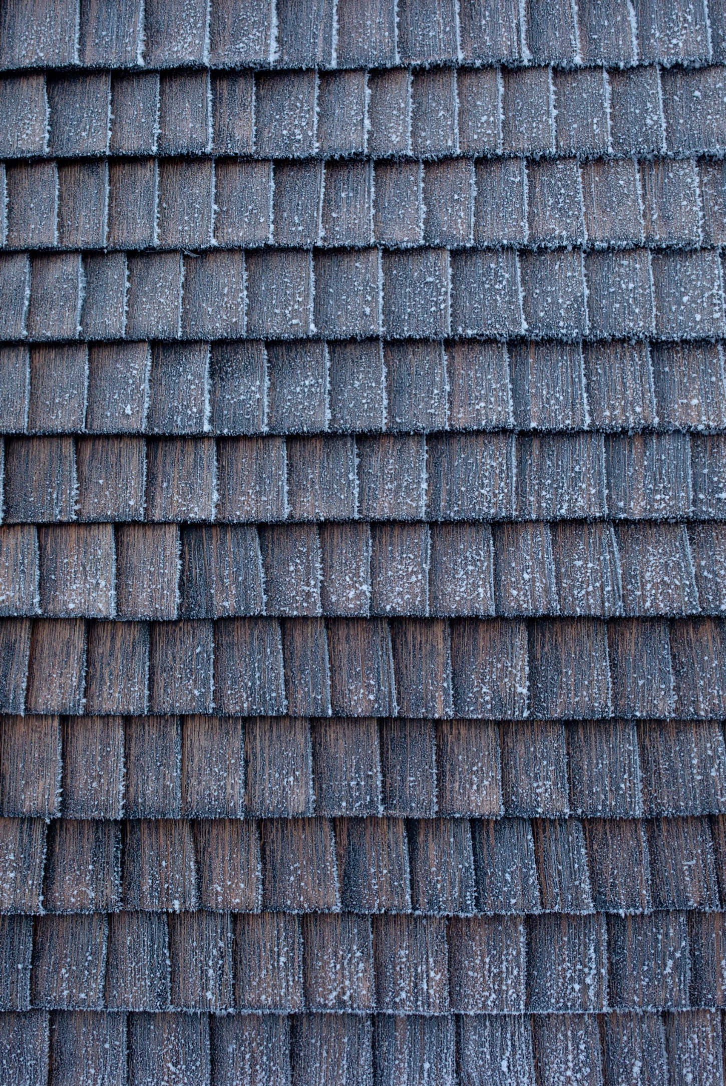 The Hotspot Oslo Works — Close-up detail of the sauna's exterior envelope reveals hand-split wooden shingles arranged in staggered horizontal courses.