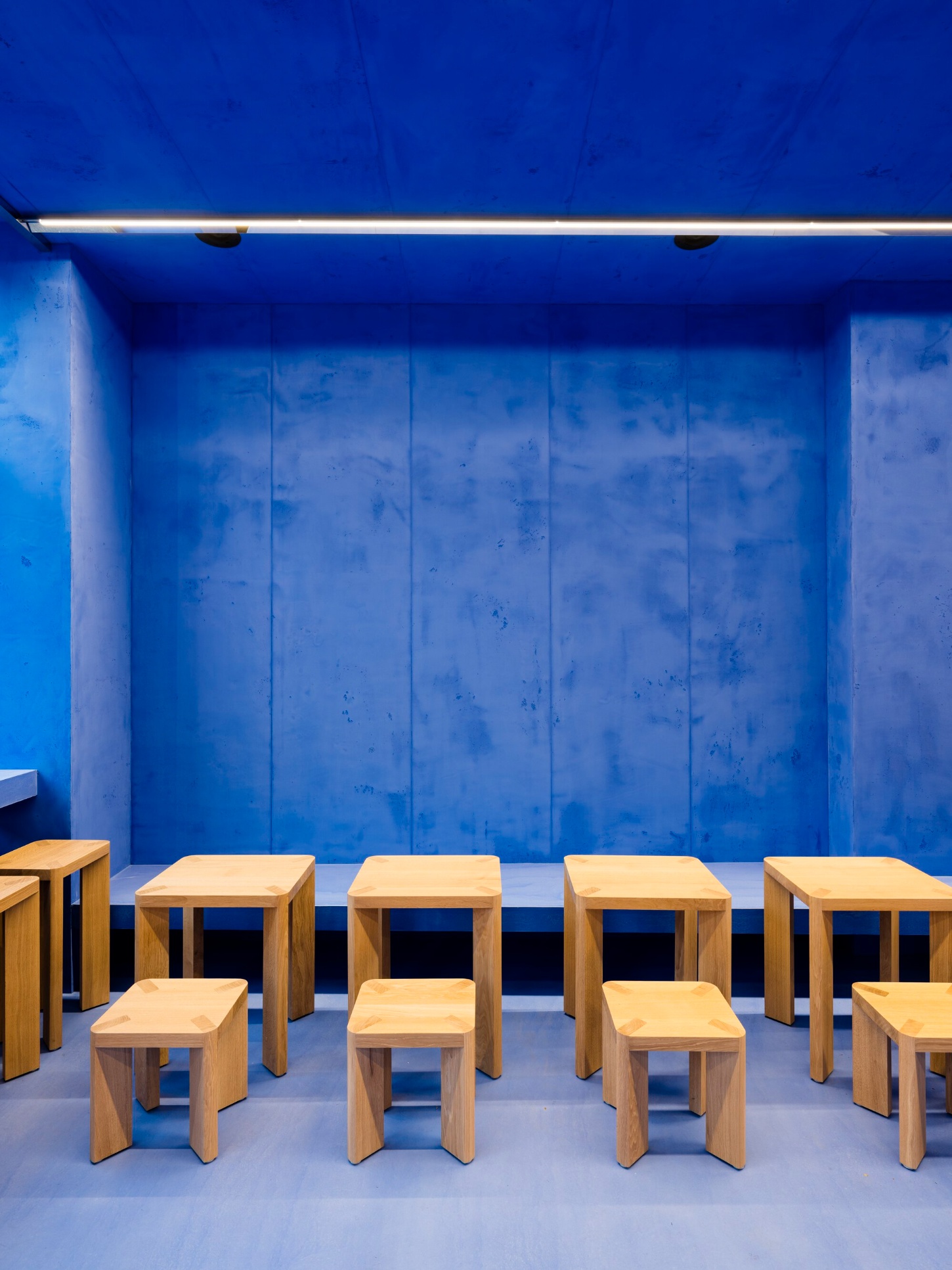Aera Bakery by Gonzalez Haase AAS — The dining area of Aera Bakery presents a rigorous spatial organization through monochromatic materiality.