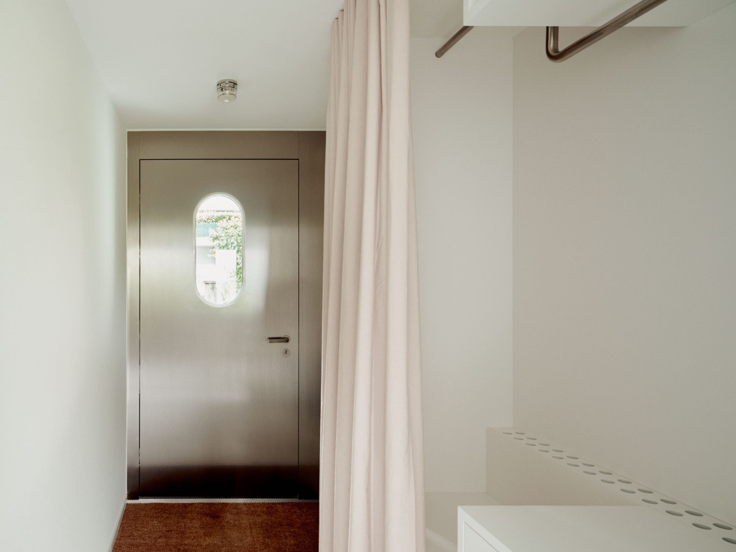 1930’s House Zurich by Ductus by Ductus St — A corridor passage frames a monolithic concrete threshold, its stepped edge creating a distinct spatial boundary.