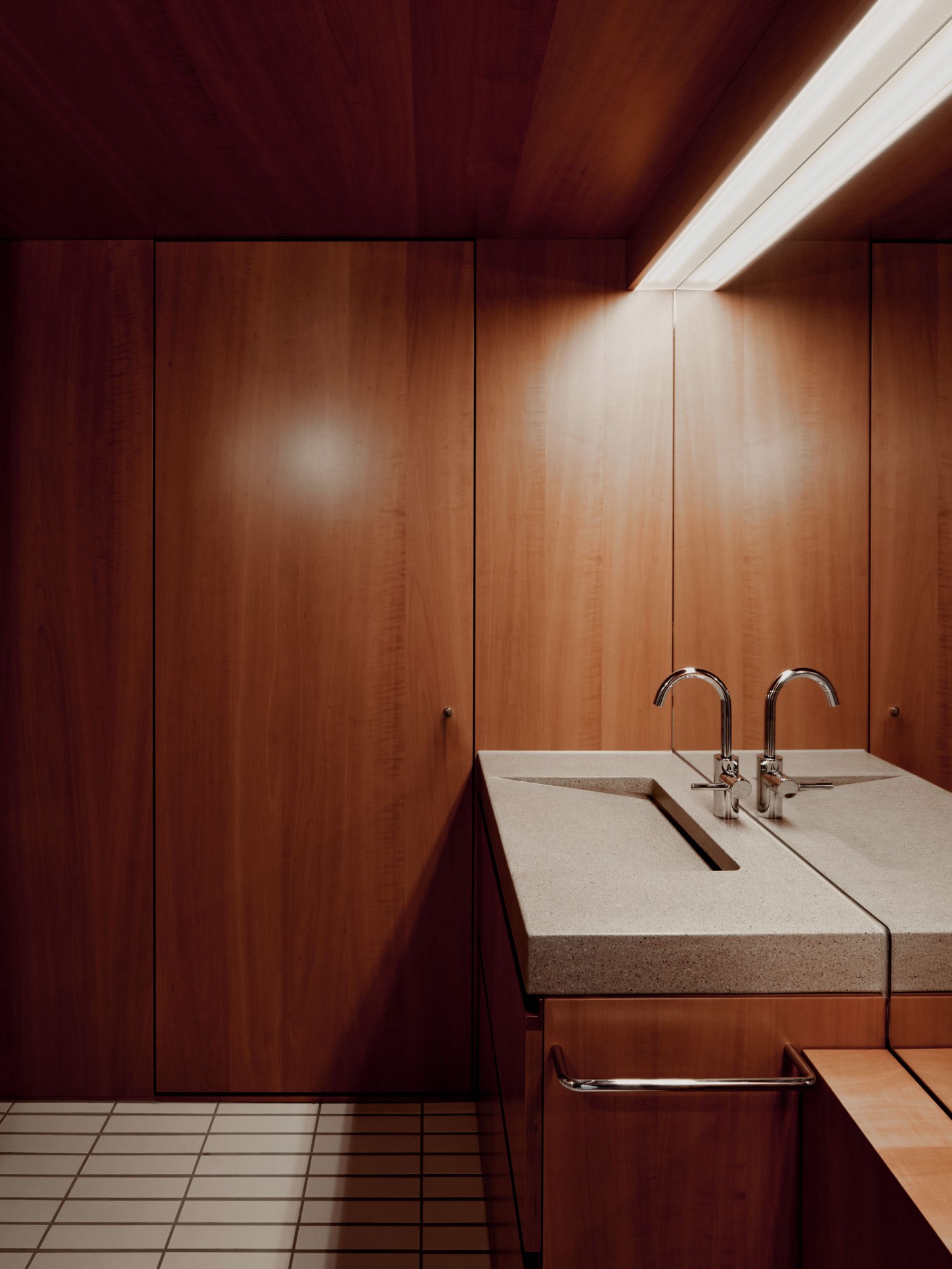 1930’s House Zurich by Ductus by Ductus St — A monolithic concrete wash counter with integral sink divides the bathroom space, its sharp edges and clean planes defining the room's primary functional...