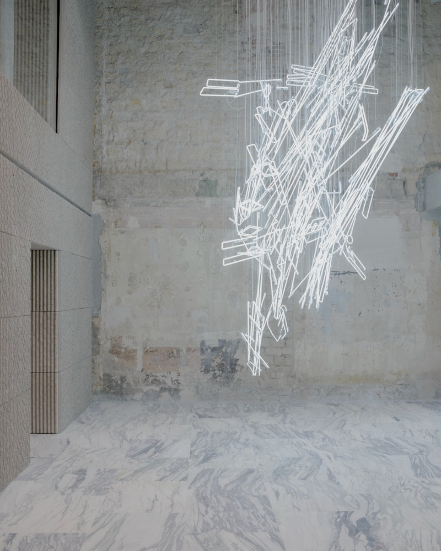 Saint Laurent Flagship in Paris by Sain Laurent — A neon line drawing installation suspended against a weathered concrete wall creates a three-dimensional sculptural presence within the retail space.