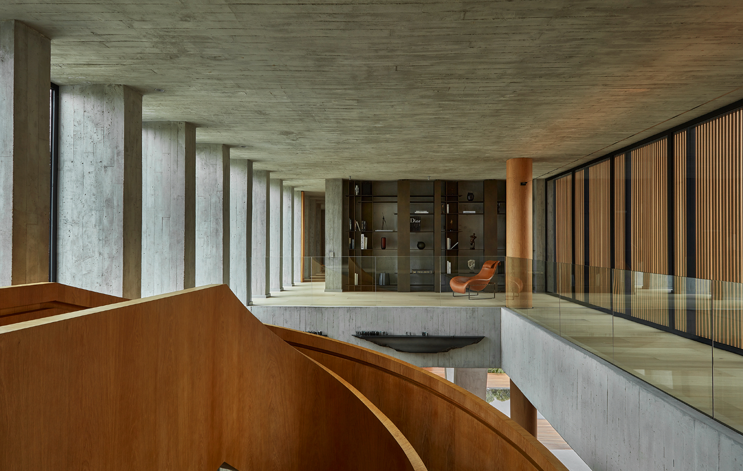 Casa Haras by 5Solidos — A double-height corridor showcases the residence's sculptural approach to materiality.