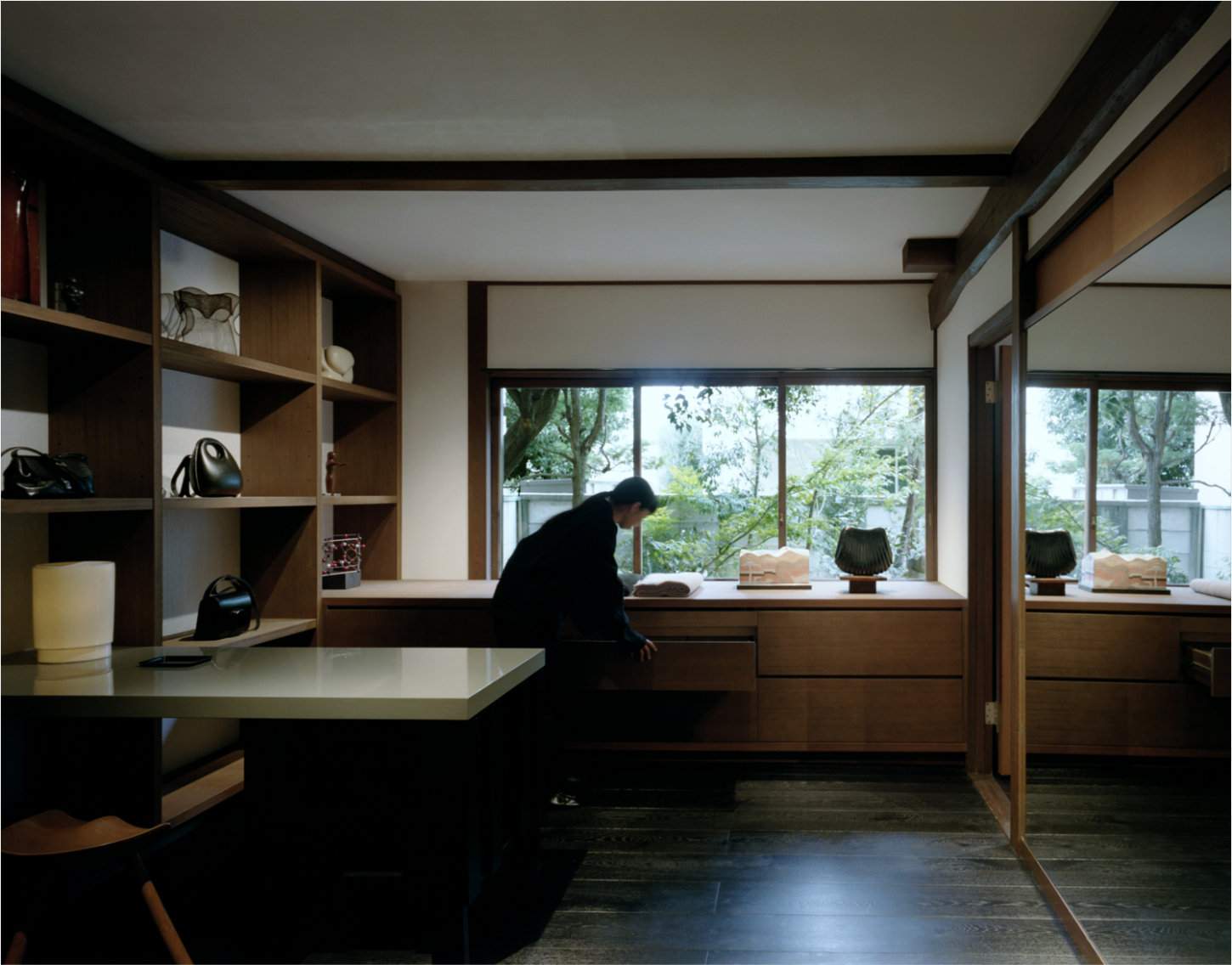 LEMAIRE Ebisu by Studio Hashimura by LEMAIRE by Studio Hashimura — A workspace defined by rectilinear timber cabinetry in warm wood tones, anchored by a continuous desk surface running beneath south-facing windows framing...