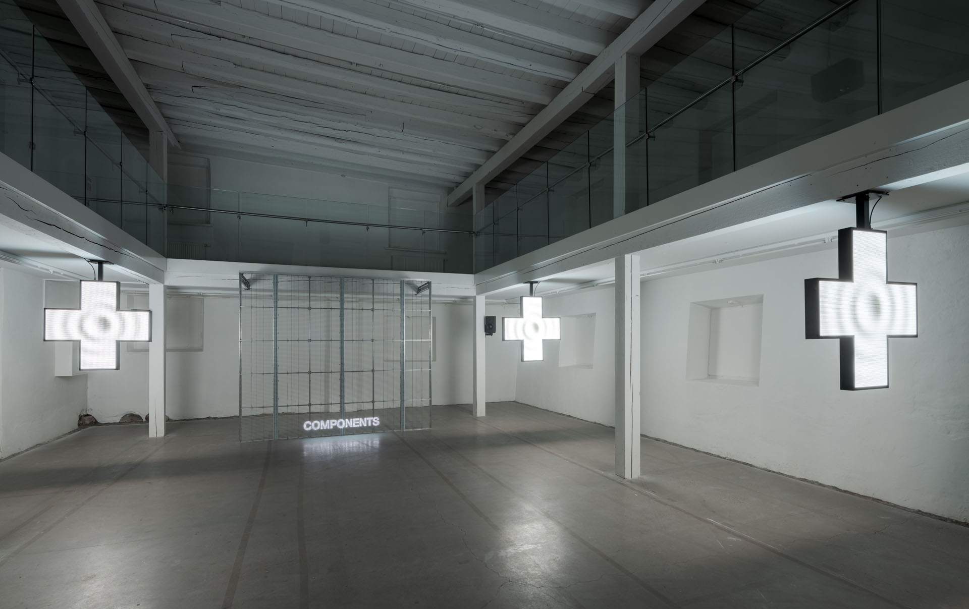 Milk Plus by Jens Settergren Viborg Kunsthal — A multi-chambered gallery installation features three suspended LED cross-forms emitting white pixel-grid light across an industrial concrete floor.