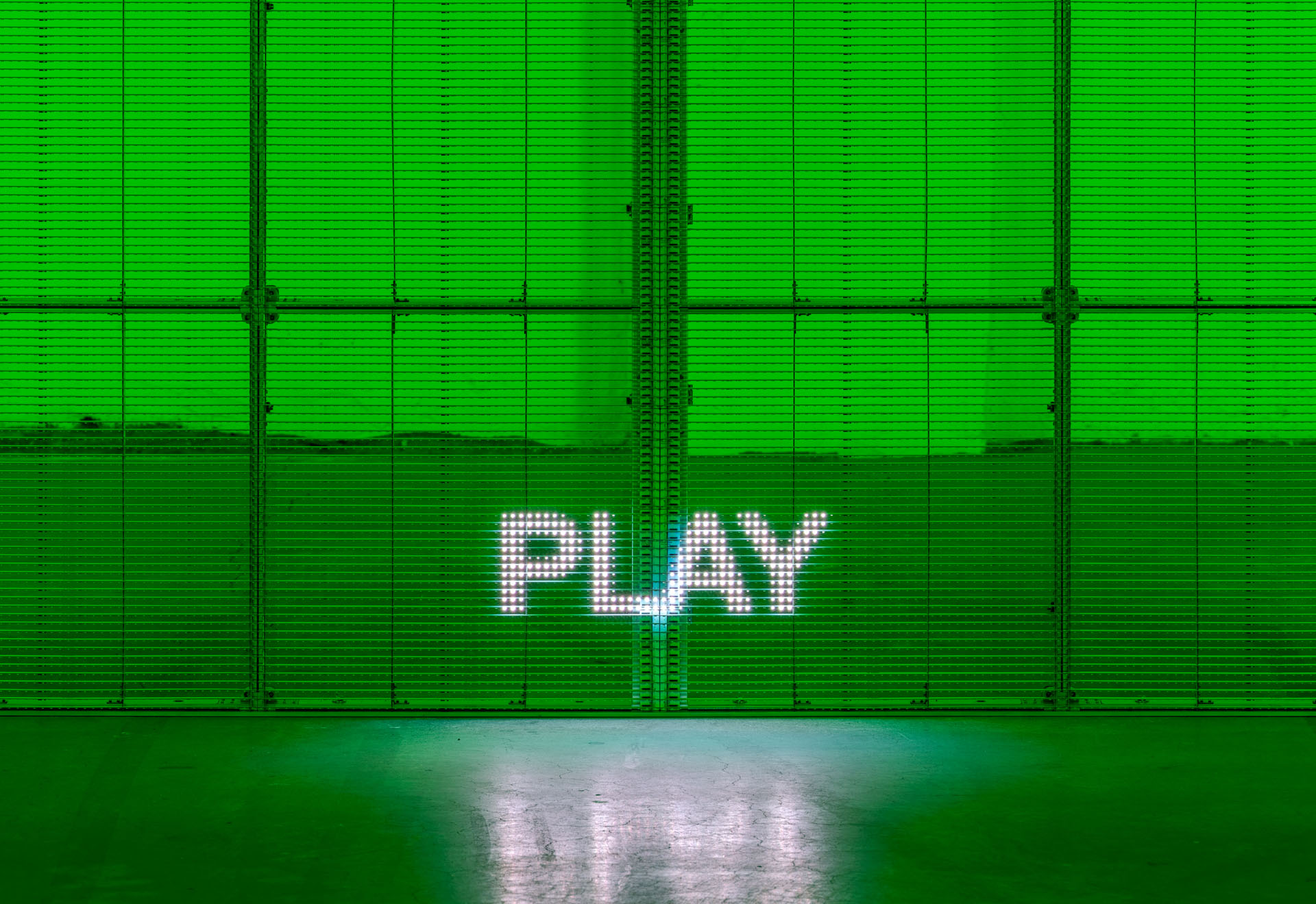 Milk Plus by Jens Settergren Viborg Kunsthal — A LED pixel display mounted on an industrial metal frame emits bright white text reading 'PLAY' against a vibrant green background.