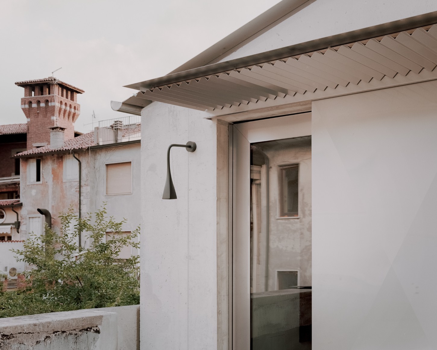 Atipografia Threshold and Treasure Gallery by AMAA — The Atipografia Threshold gallery presents a monolithic concrete pavilion with a deep cantilevered roof slab extending over an open bay.