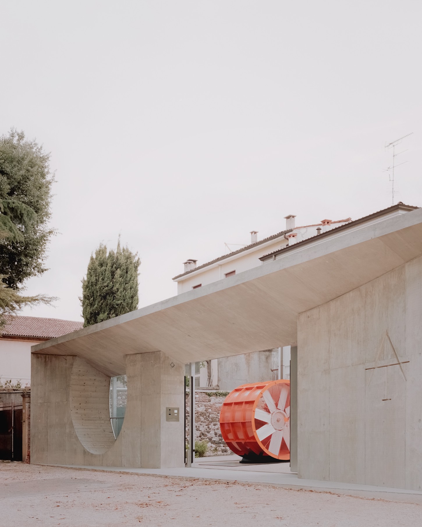Atipografia Threshold and Treasure Gallery by AMAA — The Atipografia Threshold gallery presents a minimalist concrete pavilion with a dramatic cantilevered roof slab that extends over an open bay.