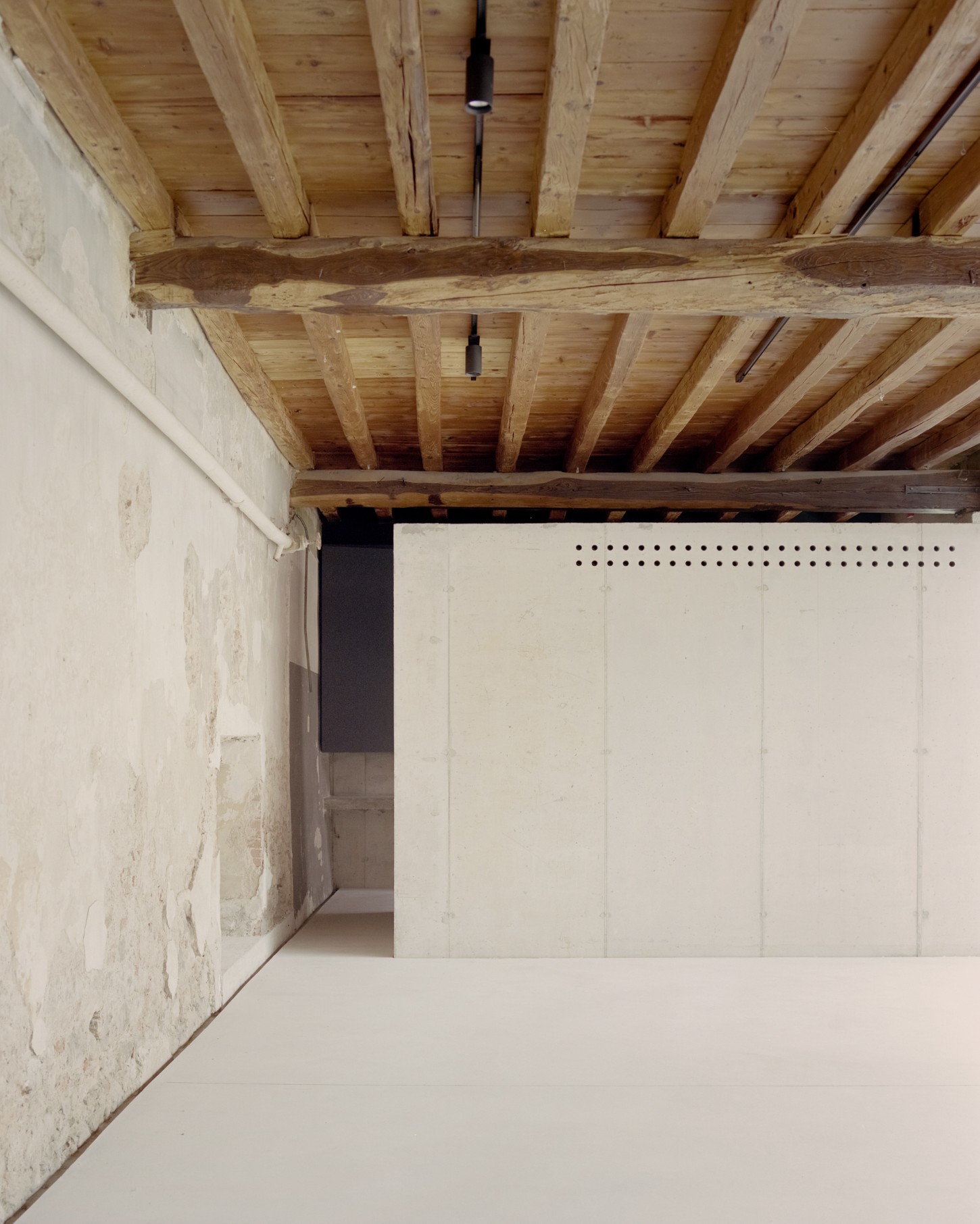 Atipografia Threshold and Treasure Gallery by AMAA — An interior view of the Atipografia Threshold and Treasure Gallery reveals the structural logic of the renovation.