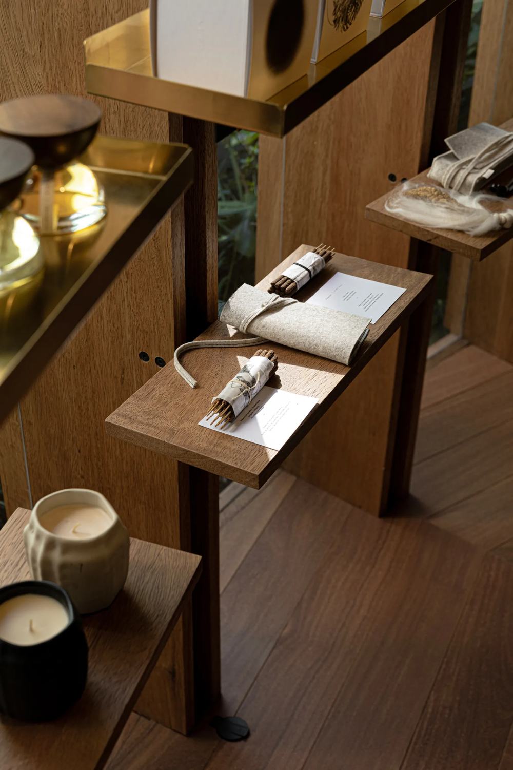 Xinú Marsella by Esrawe Studio by Estrawe Studio — Detail view of Xinú Marsella's retail shelving system, showcasing cantilevered timber arms extending from central wooden supports.