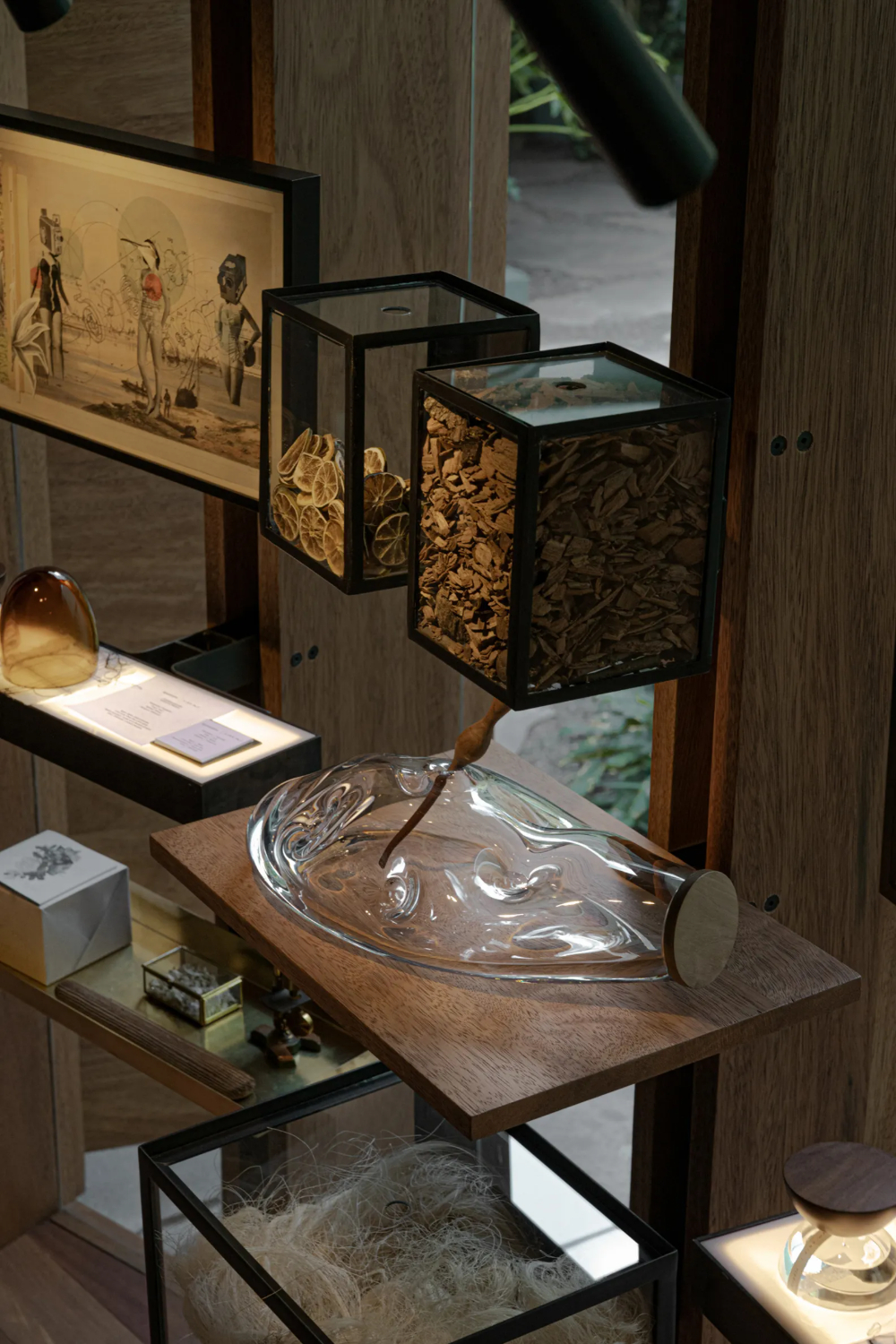 Xinú Marsella by Esrawe Studio by Estrawe Studio — A display pavilion within Xinú Marsella features a cantilevered timber shelf system supporting an assemblage of vessels and sculptural objects.