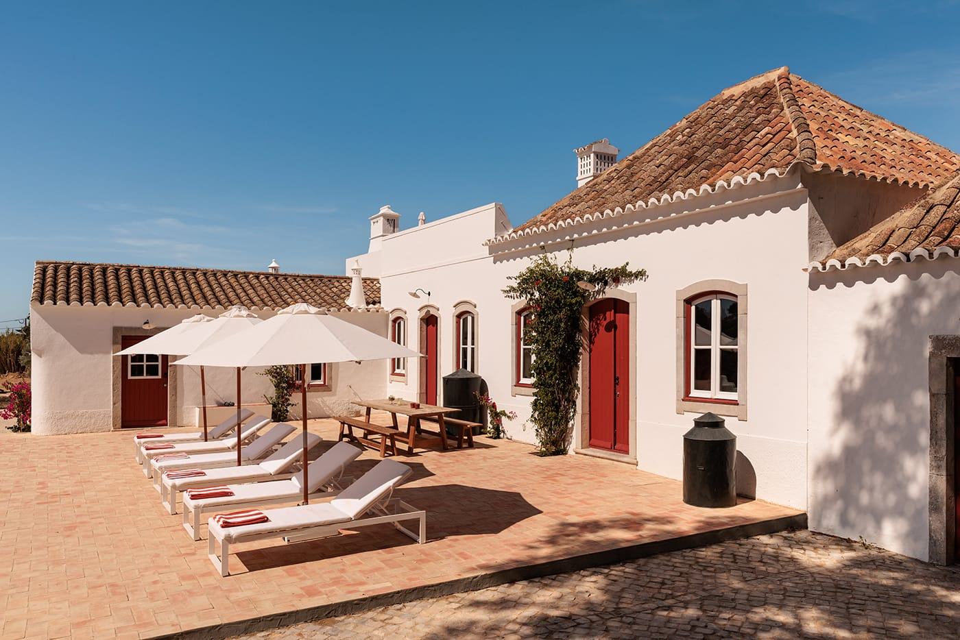 Quinta do Pinheiro by Frederico Valsassina — The courtyard of Quinta do Pinheiro presents a deliberate arrangement of terracotta tile flooring anchoring a composition of whitewashed render walls...