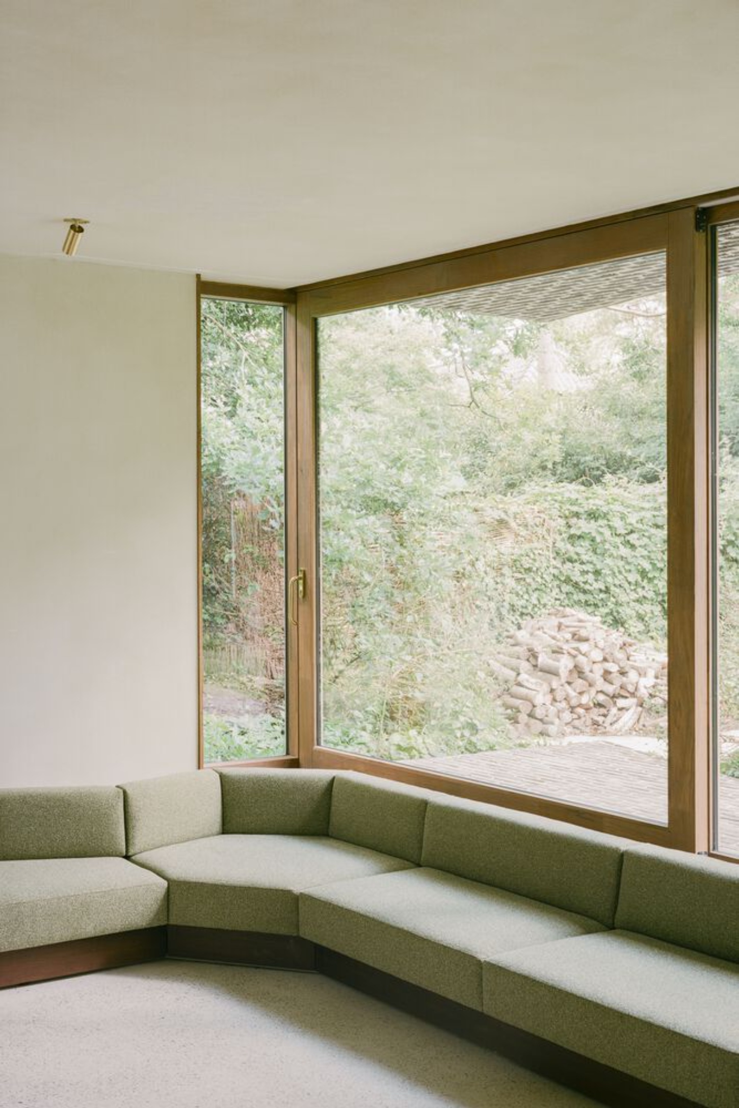 BD House by Space Encounters + Studio Vincent Architecture — A corner window configuration frames the wooded landscape beyond, with flush-glazed aluminum frames spanning the full facade width.