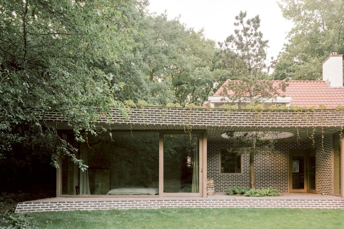 BD House by Space Encounters + Studio Vincent Architecture — The garden facade of BD House presents a rhythmic composition of horizontal brick coursing interrupted by flush glazing that spans the full width of the...