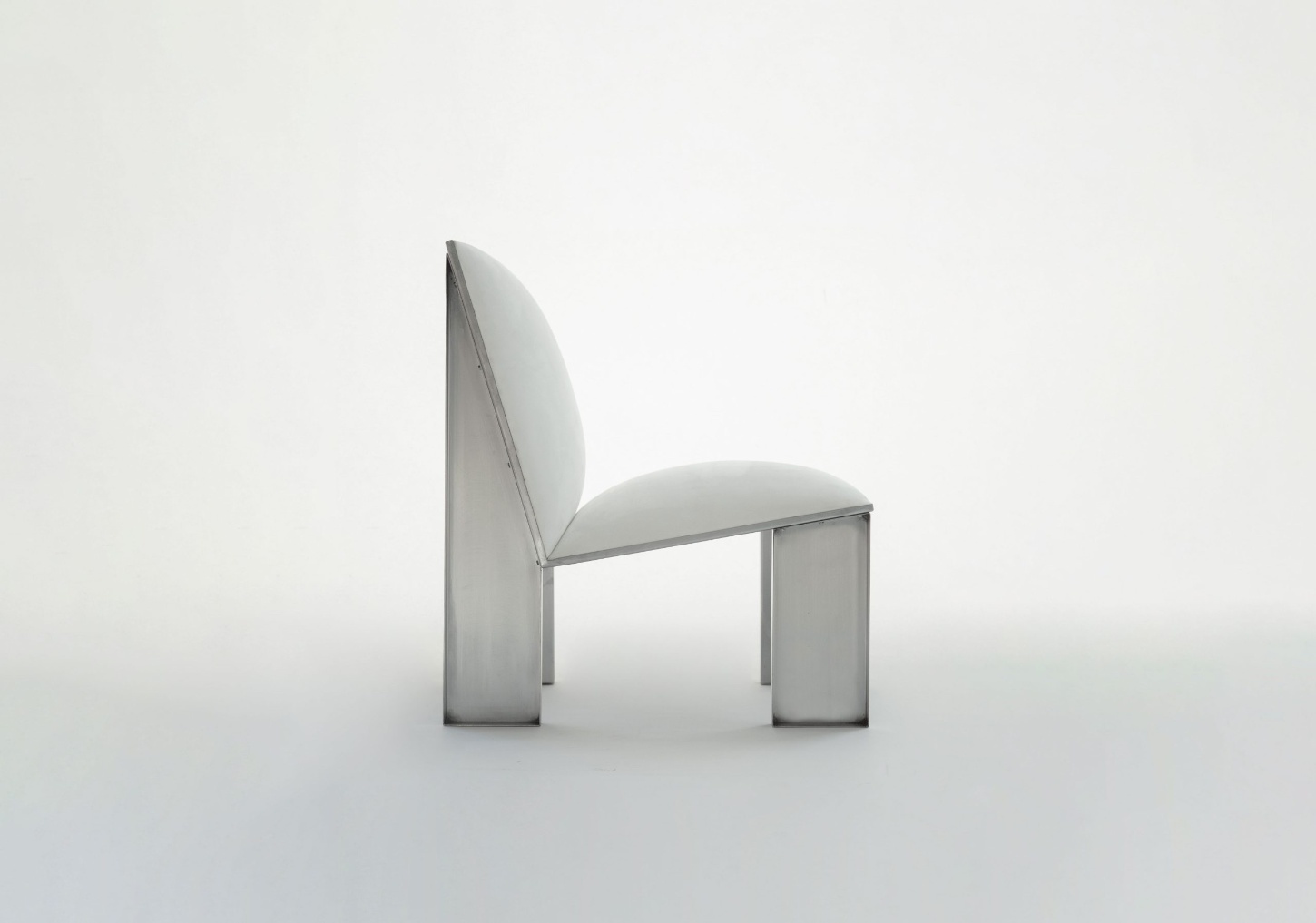 Ele Armchair by Jaume Ramirez Studio — The Ele Armchair presents a study in material contradiction: a tubular steel frame with cylindrical legs supports an upholstered form that appears to defy...