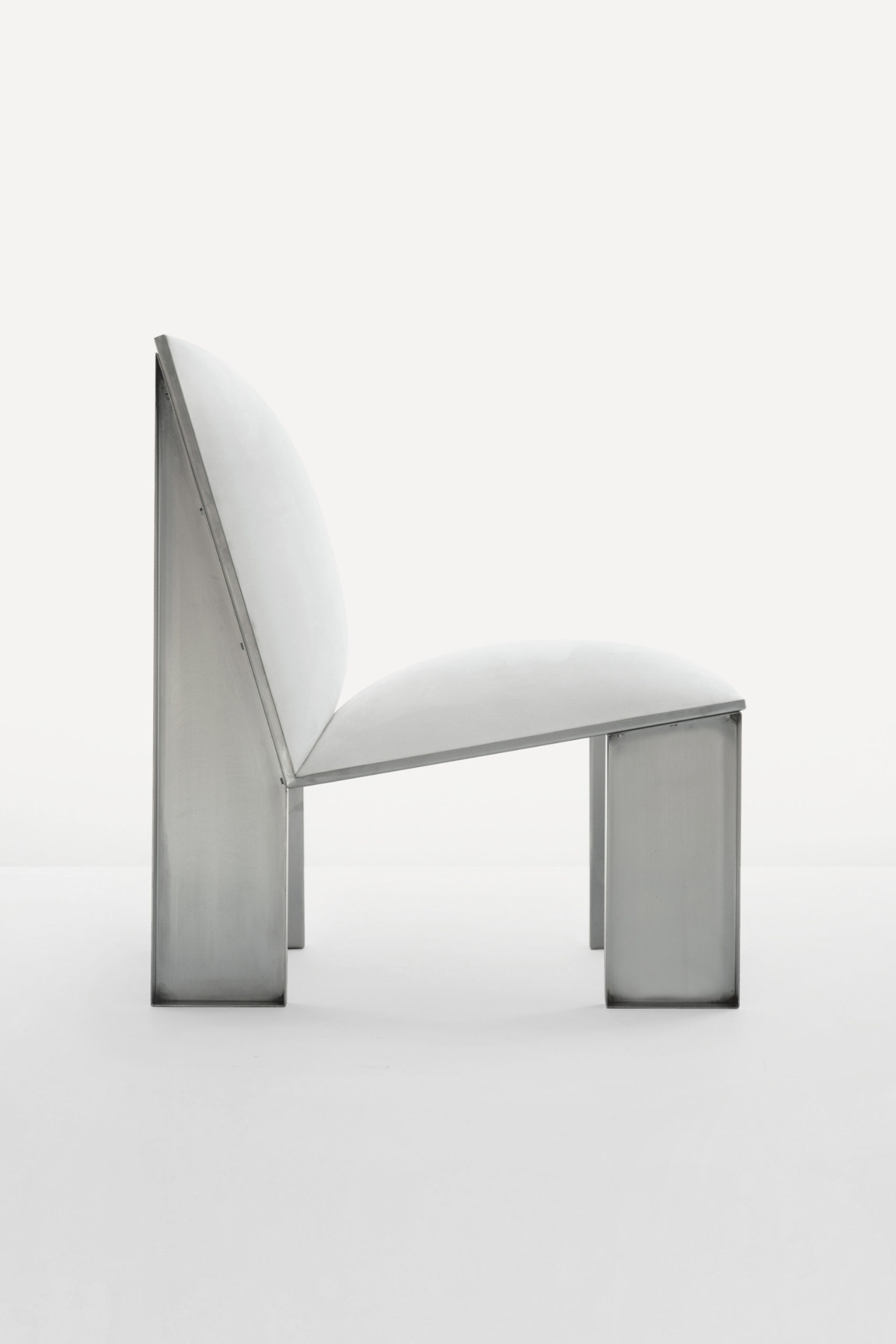 Ele Armchair by Jaume Ramirez Studio — The Ele Armchair presents a study in material contrast: a skeletal structure of tubular steel with cylindrical legs supports a dramatically overscaled,...
