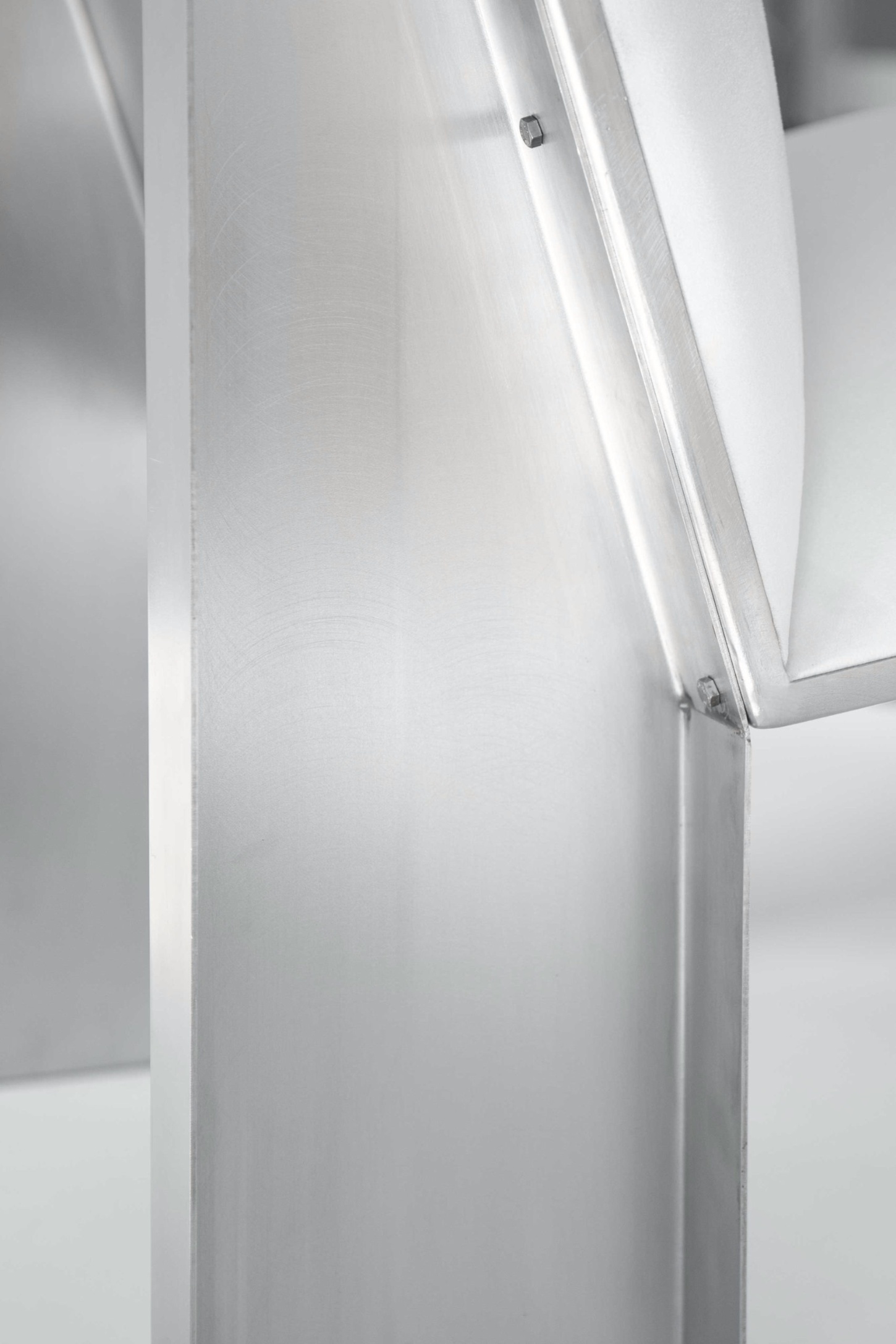 Ele Armchair by Jaume Ramirez Studio — Close-up detail of the Ele Armchair's structural joint, capturing where the tubular aluminum frame meets the upholstered form.