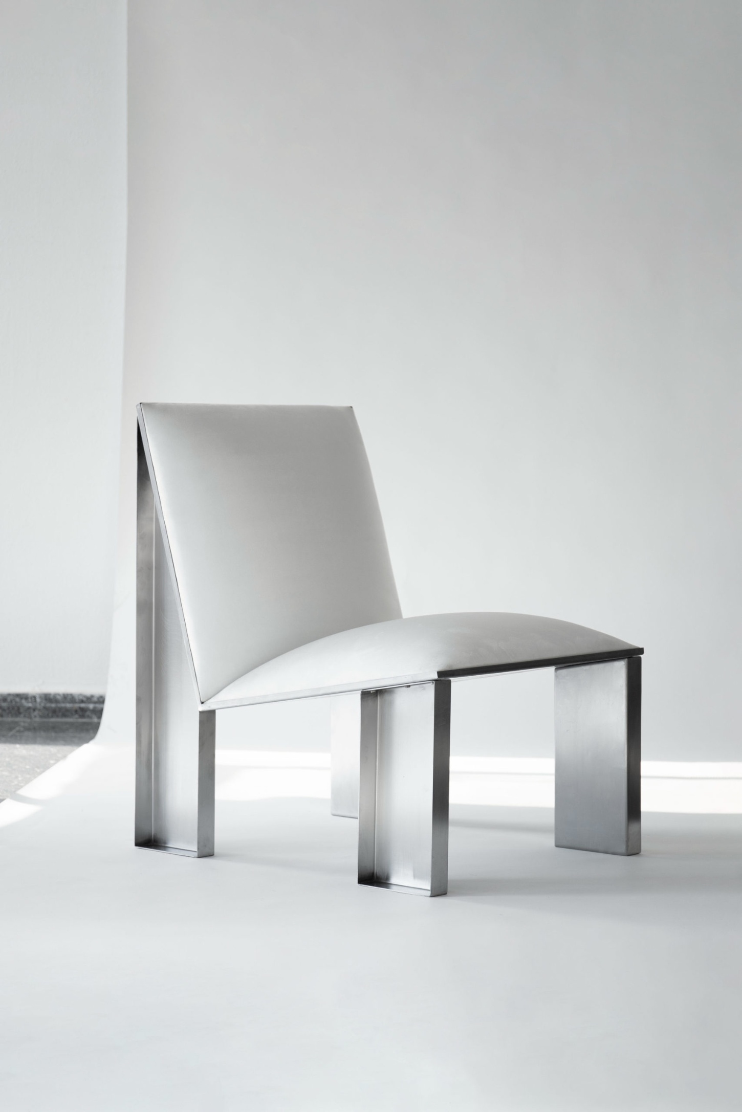 Ele Armchair by Jaume Ramirez Studio — The Ele Armchair presents a stark compositional contrast between its welded tubular steel frame and voluminous upholstered form.