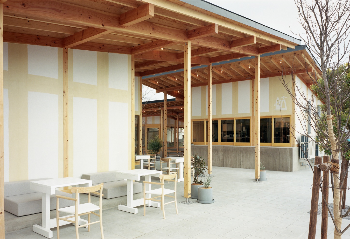 Funamachi Base Store by Jo Nagasaka + Schemata Architects — A timber-framed courtyard pavilion with post-and-beam construction showcasing exposed wooden beam grids and regularly-spaced structural columns.