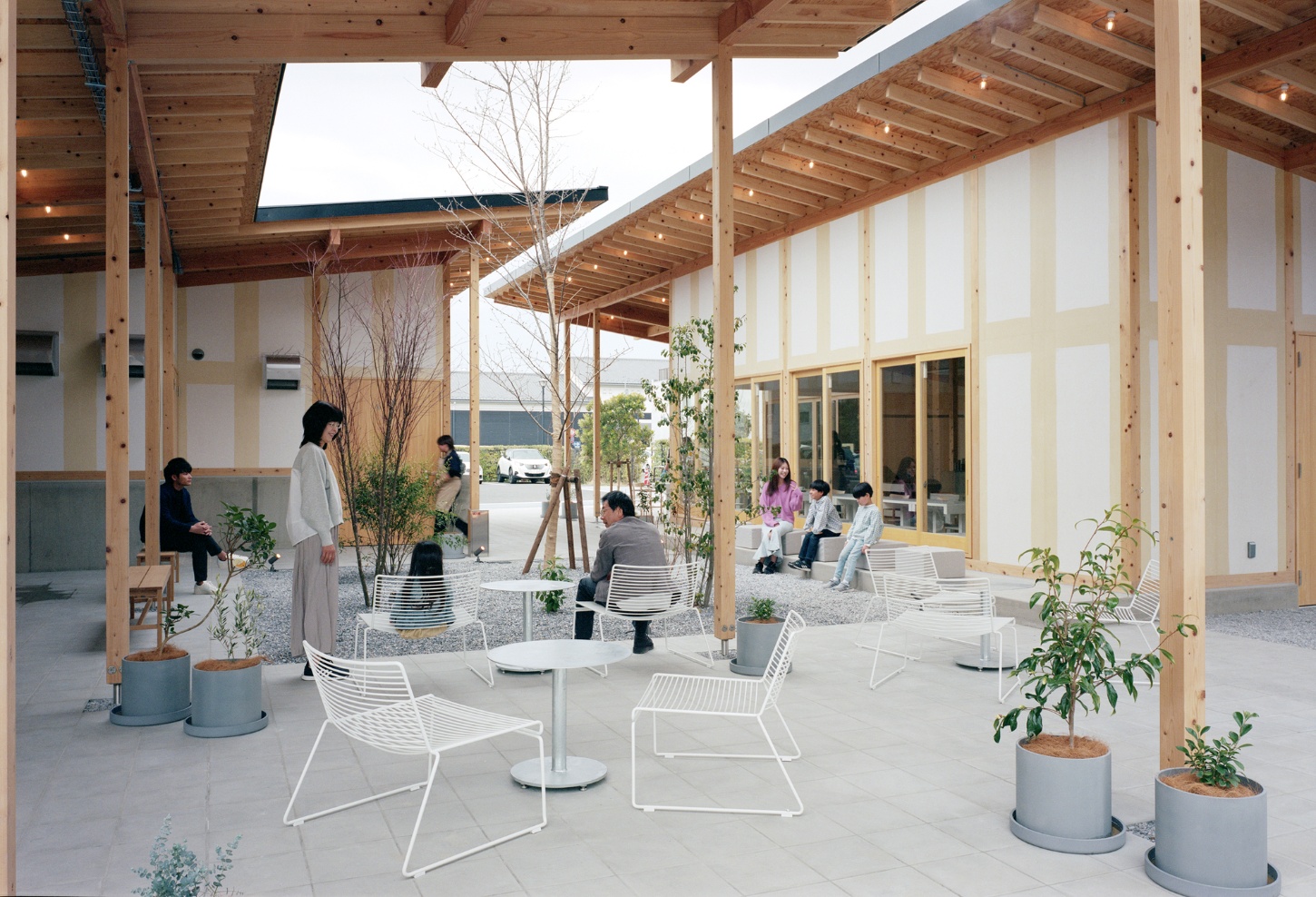 Funamachi Base Store by Jo Nagasaka + Schemata Architects — A covered courtyard at Funamachi Base Store unfolds as a semi-open landscape, its timber post-and-beam structure creating a rhythmic grid overhead.