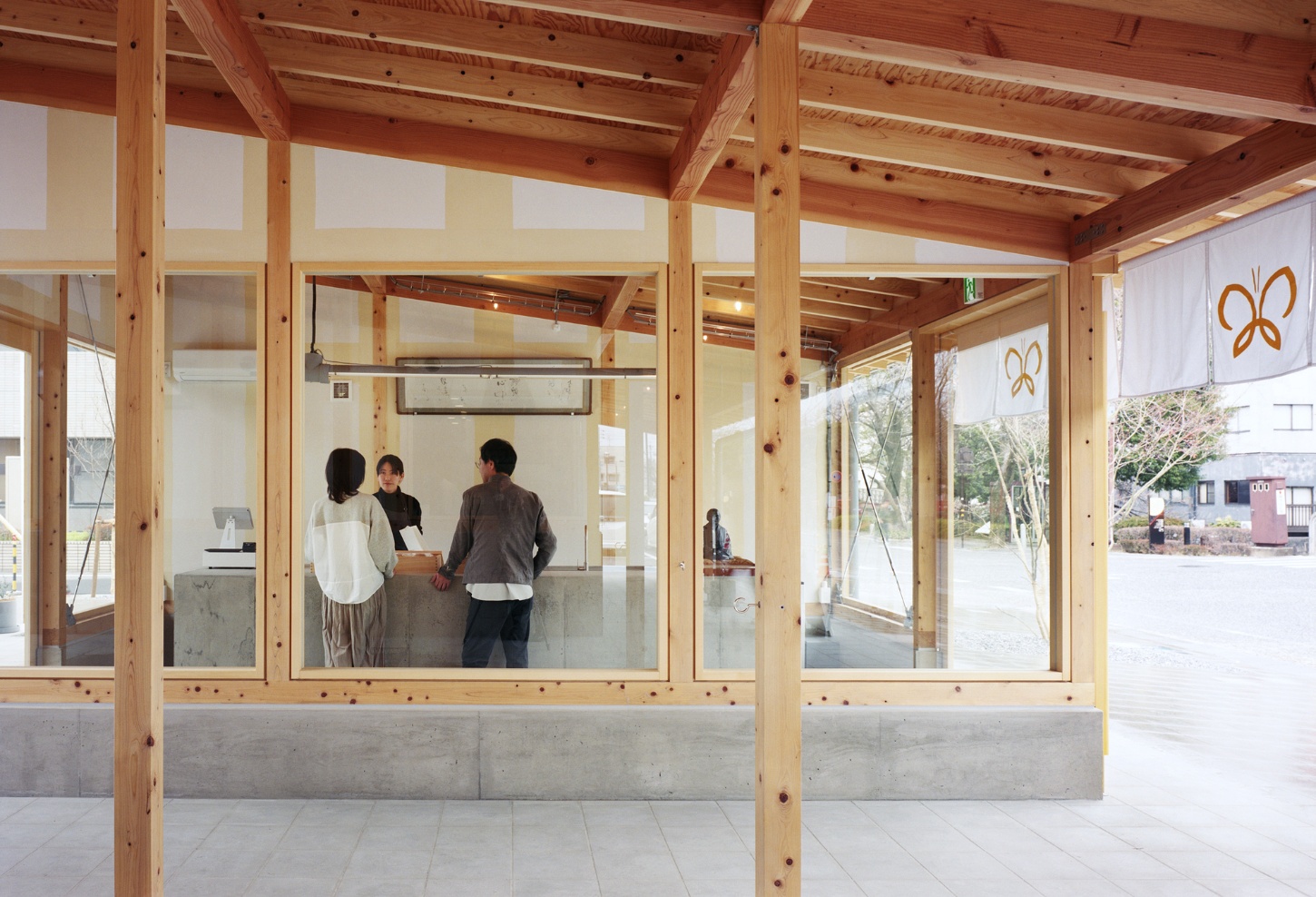 Funamachi Base Store by Jo Nagasaka + Schemata Architects — The interior threshold reveals a post-and-beam timber structural system with regularly spaced columns and exposed fasteners overhead.