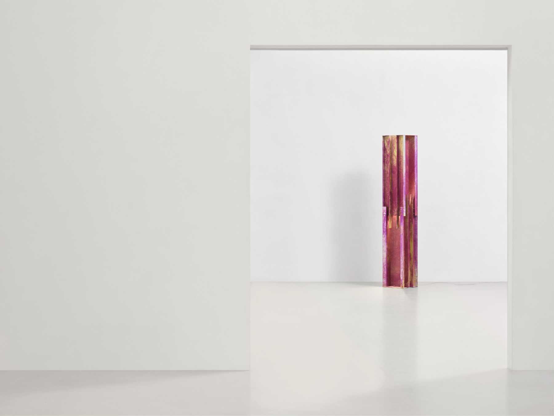 Anodized Collection by Paul Coenen — A hand-anodized aluminum column dominates the composition, positioned vertically against a white gallery wall.
