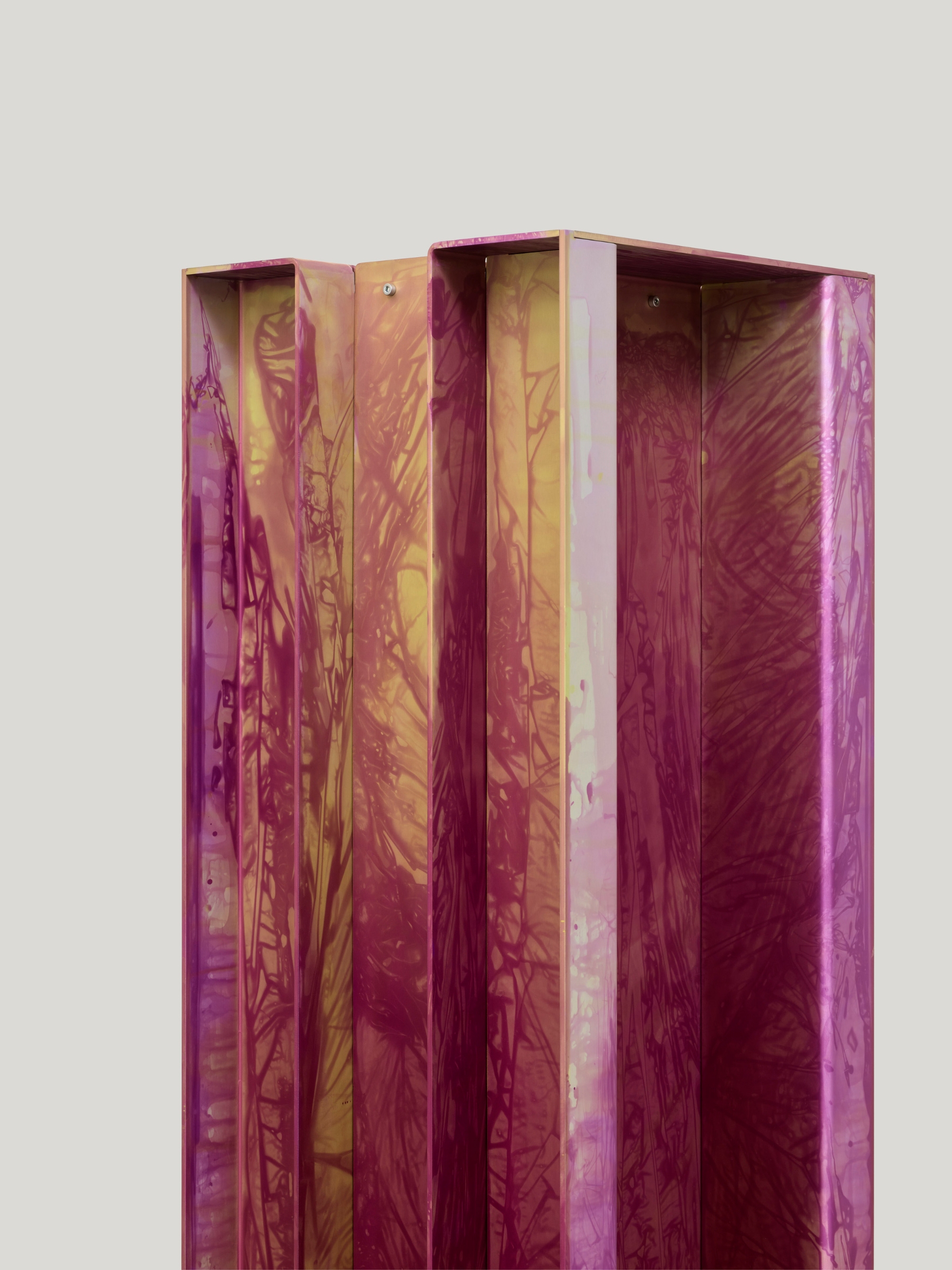 Anodized Collection by Paul Coenen — A tall anodized aluminum column in vivid magenta and burgundy tones, with hand-applied dye creating rippling surface patterns that shift across the vertical...