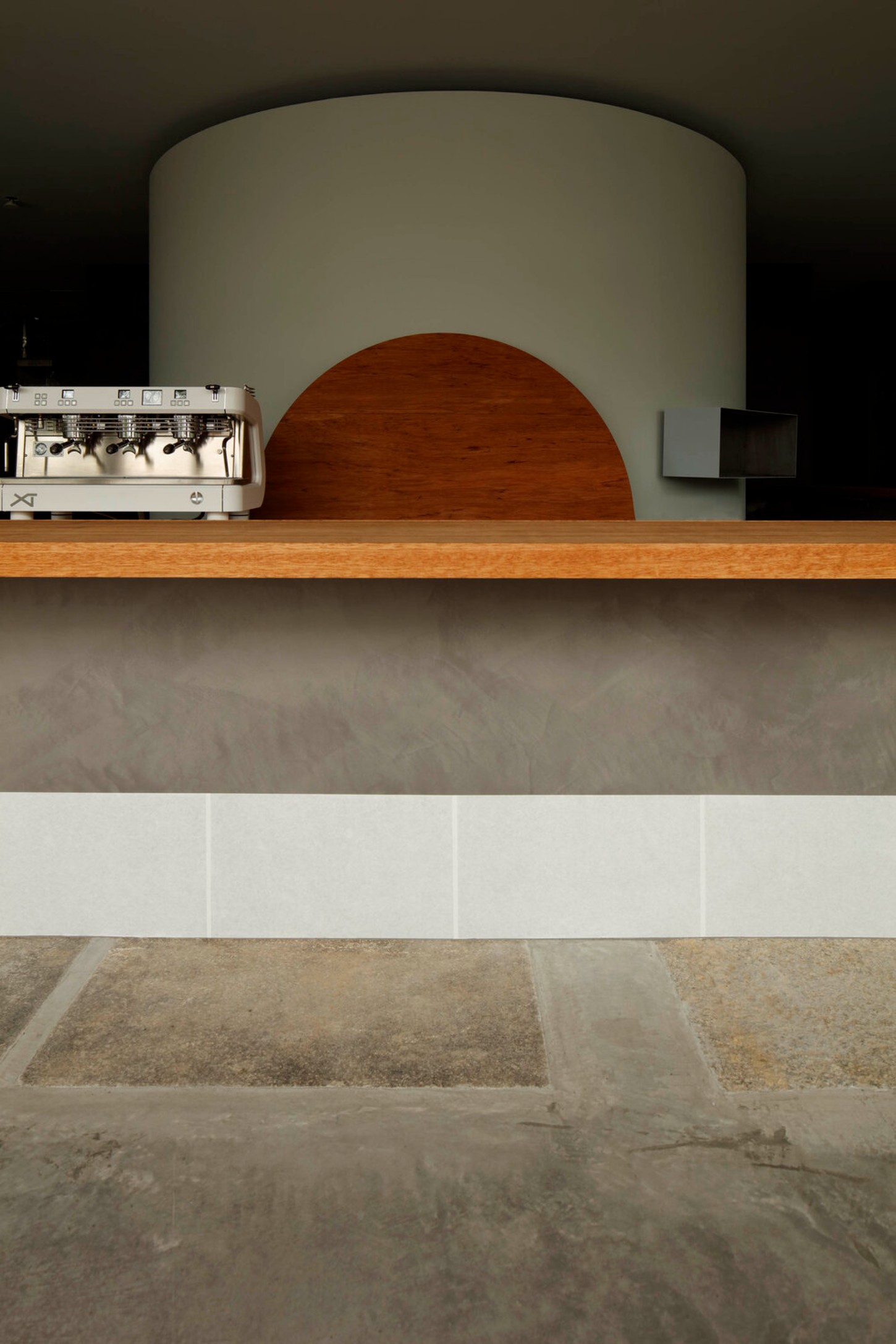 OGAWA COFFEE LABORATORY by Yusuke Seki Studio — Ground-level view of the KURA bean cellar at Ogawa Coffee Laboratory, emphasizing the monolithic white plaster cylinder as a sculptural storage form.