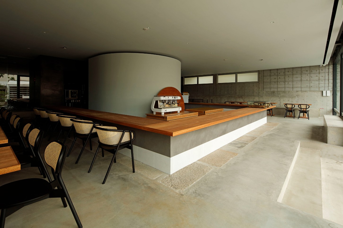 OGAWA COFFEE LABORATORY by Yusuke Seki Studio — The KURA bean cellar anchors this coffee laboratory as a monolithic cylindrical form in white plaster, positioned centrally within the open-plan interior.