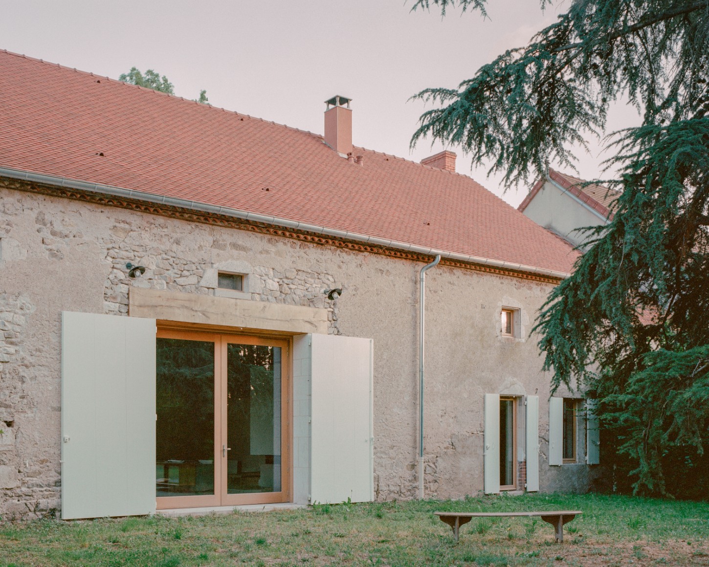 Chamboirat by COVE Architectes — The renovated barn's courtyard facade presents a dialogue of materials and eras: uncoursed stone walls with lime mortar joints form the original structure,...