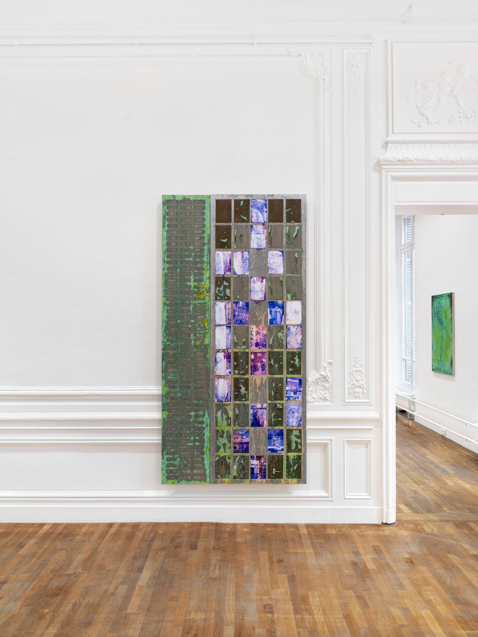 Lies by Mimosa Echard at Galerie Chantal Crousel — A tall vertical mixed-media work combines oxidized metallic panels with photographic imagery documenting architectural interiors.