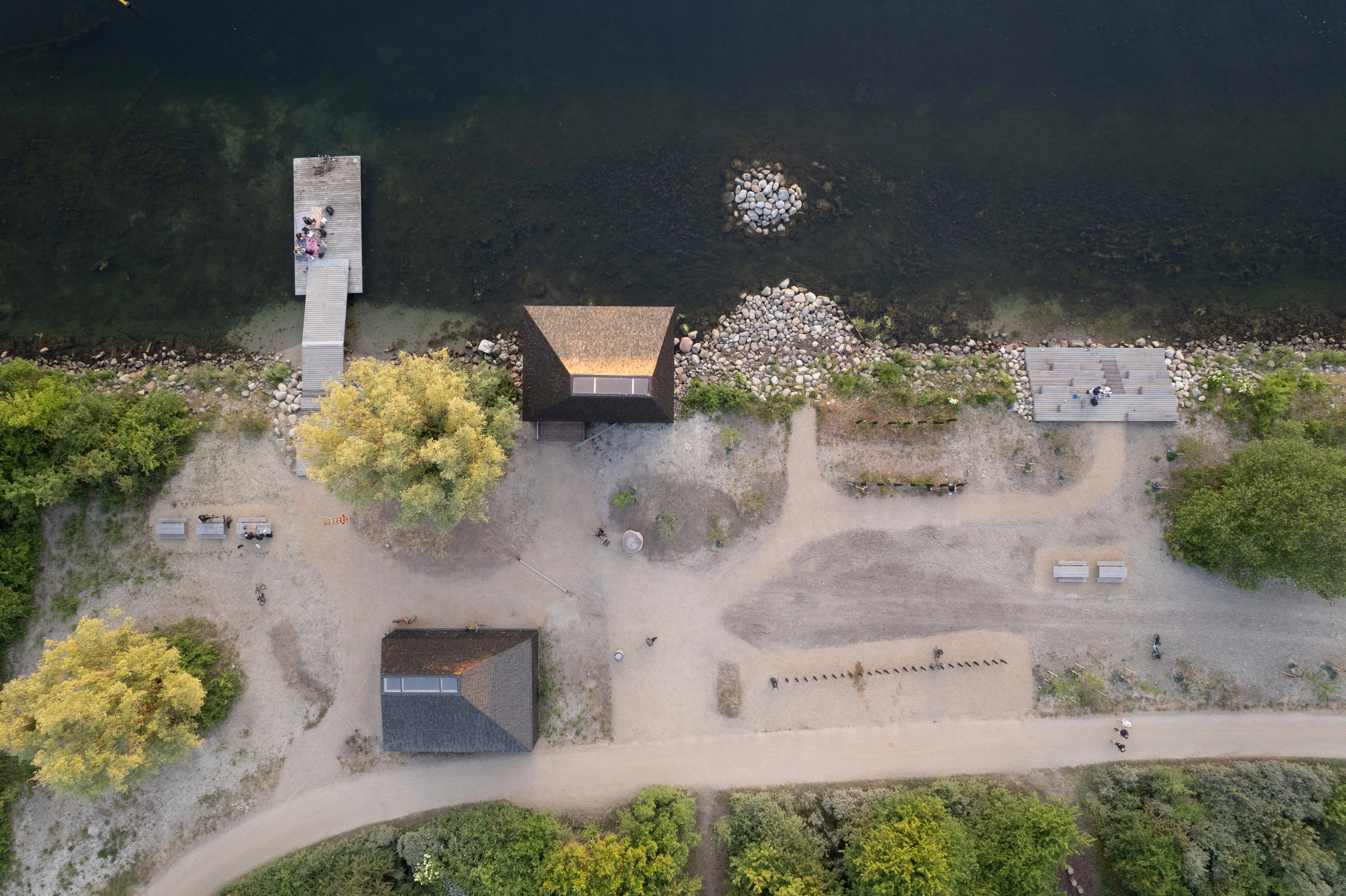 Amager Nature Park by ADEPT and LYTT Architecture — Aerial view of a visitor pavilion at Amager Nature Park, its dark cedar-shingled conical roof dominating the composition.