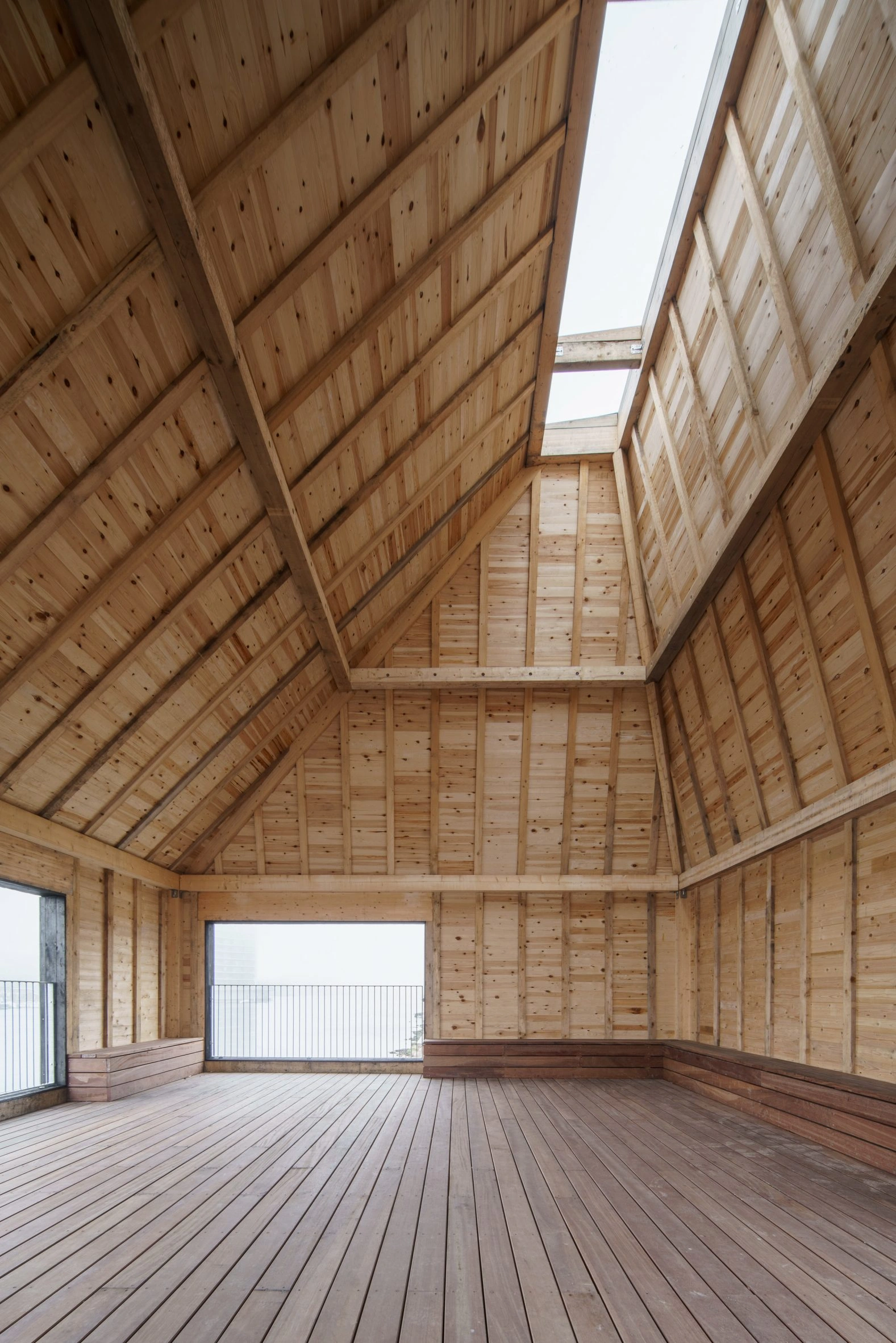 Amager Nature Park by ADEPT and LYTT Architecture — Interior view of a timber-framed pavilion with a pyramidal roof structure.