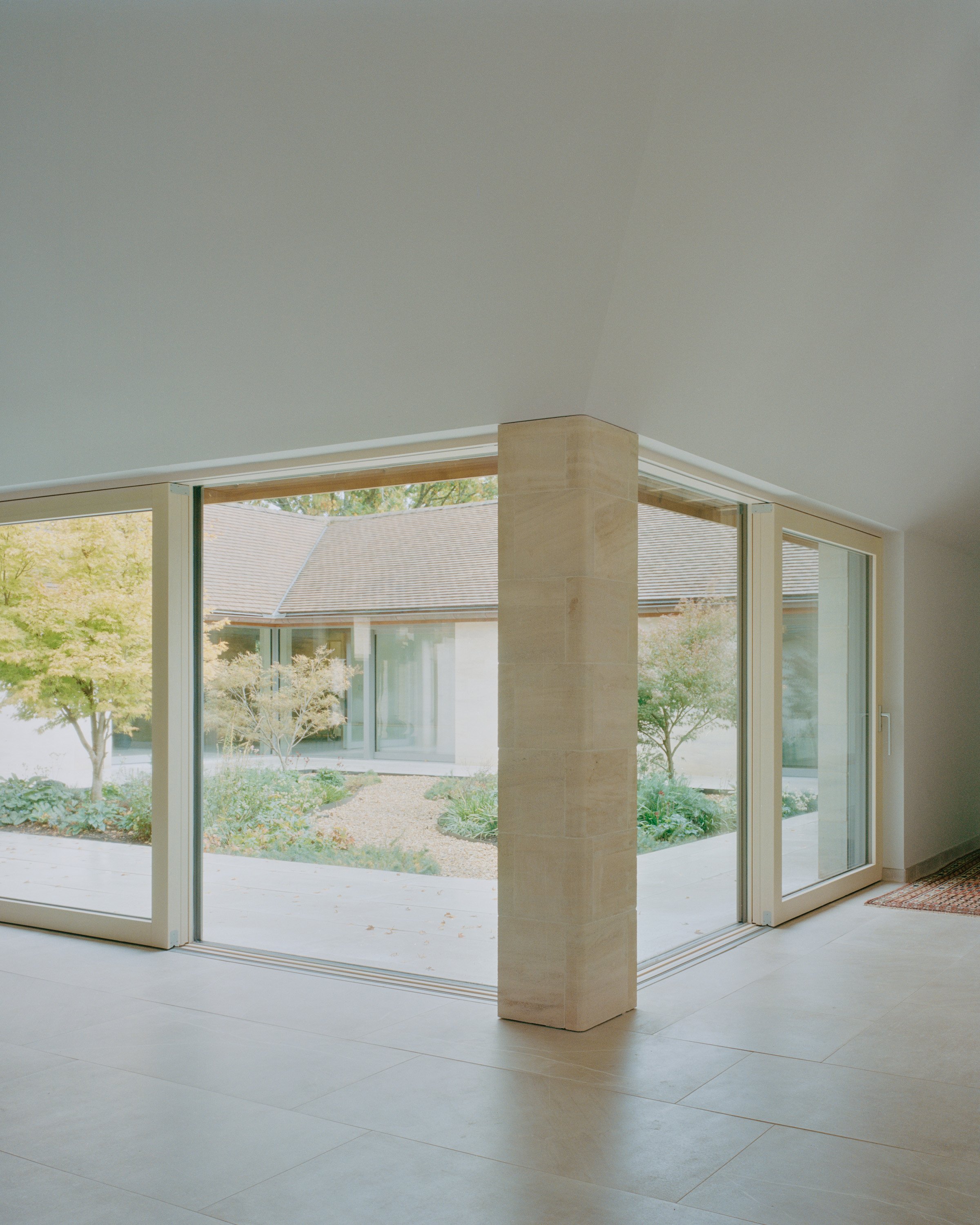 Eavesdrop by Tom Dowdall — Interior threshold of Eavesdrop, framed through continuous horizontal glazing that dissolves the boundary between interior and exterior.