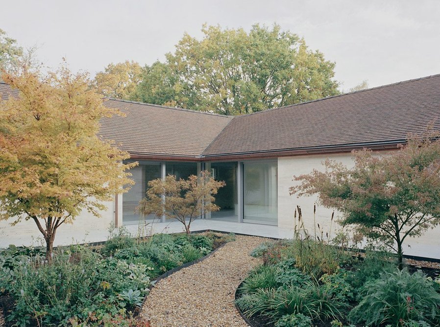 Eavesdrop by Tom Dowdall — Eavesdrop's rendered façade presents itself across a gravel forecourt framed by deciduous trees in autumn transition.