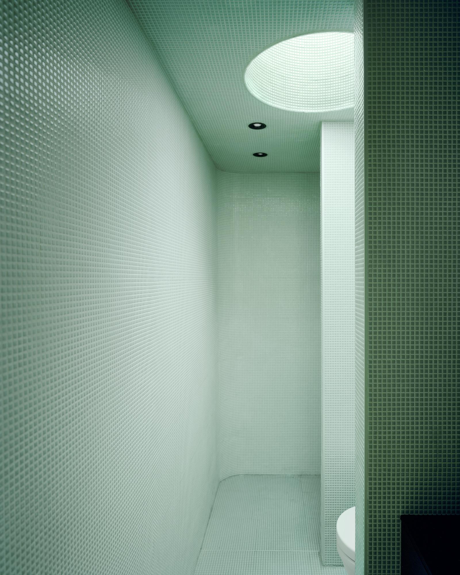 Boat House (Naust) by Espen Surnevik — Interior view of a narrow passage clad entirely in pale green small-format tile, creating a monolithic, rectilinear volume.
