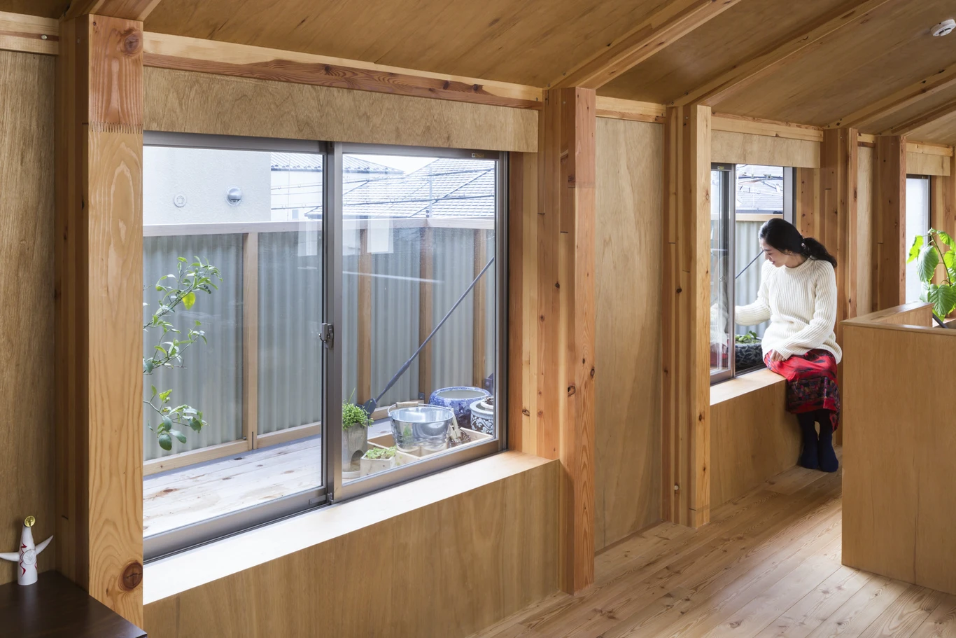 House A/Shop B (Bolts Hardware Store) by KimuraMatsumoto Architects — Interior passage lined with timber framing and plywood infill, demonstrating the post-and-beam structural system.