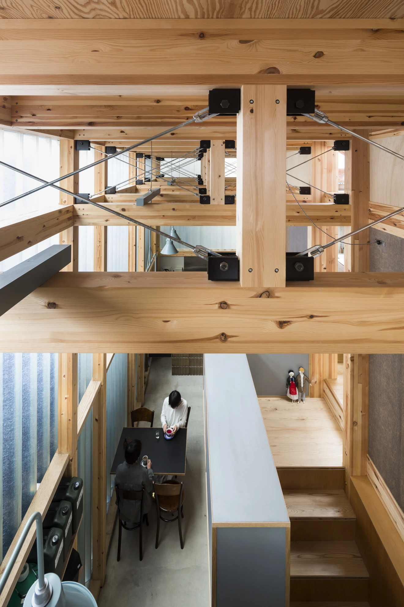 House A/Shop B (Bolts Hardware Store) by KimuraMatsumoto Architects — The upper image reveals the structural skeleton of House A/Shop B from within: exposed timber beams and posts in pale pine form a post-and-beam framework,...