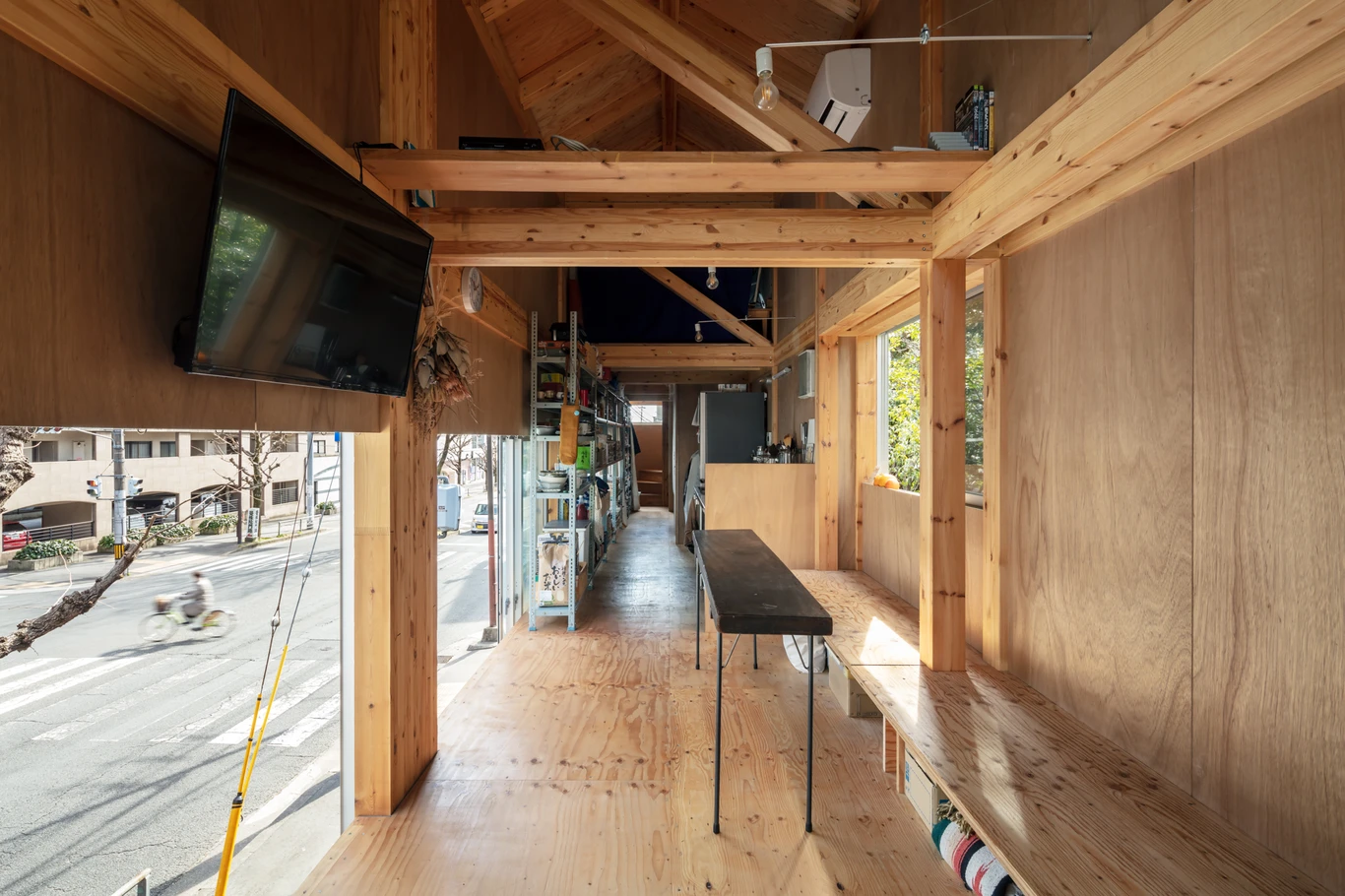 House S/Shop B (ba hütte) by KimuraMatsumoto Architects — A longitudinal view through House S/Shop B reveals the post-and-beam timber structure that spans the narrow plot's depth.